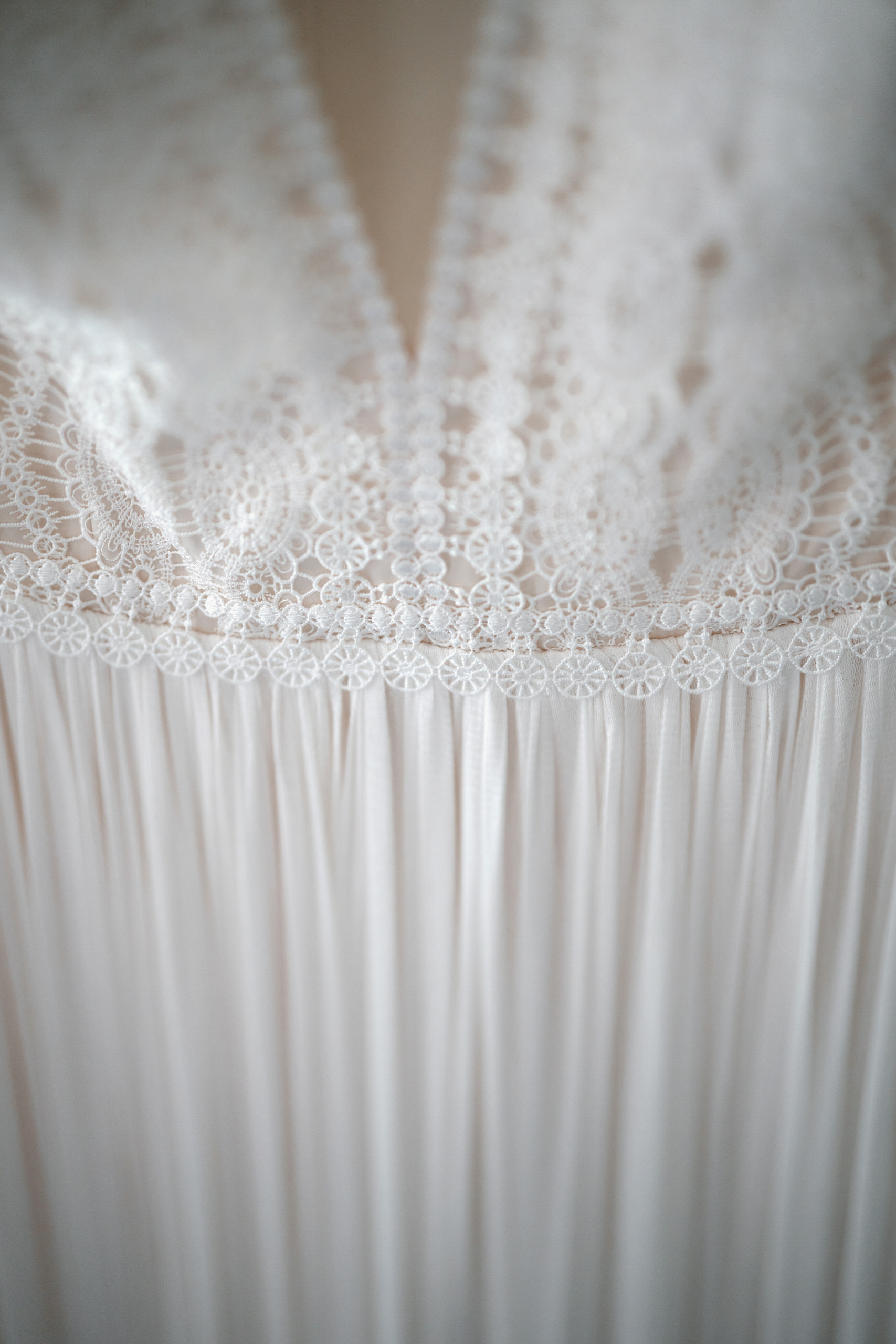A detailed look at a white lace dress.