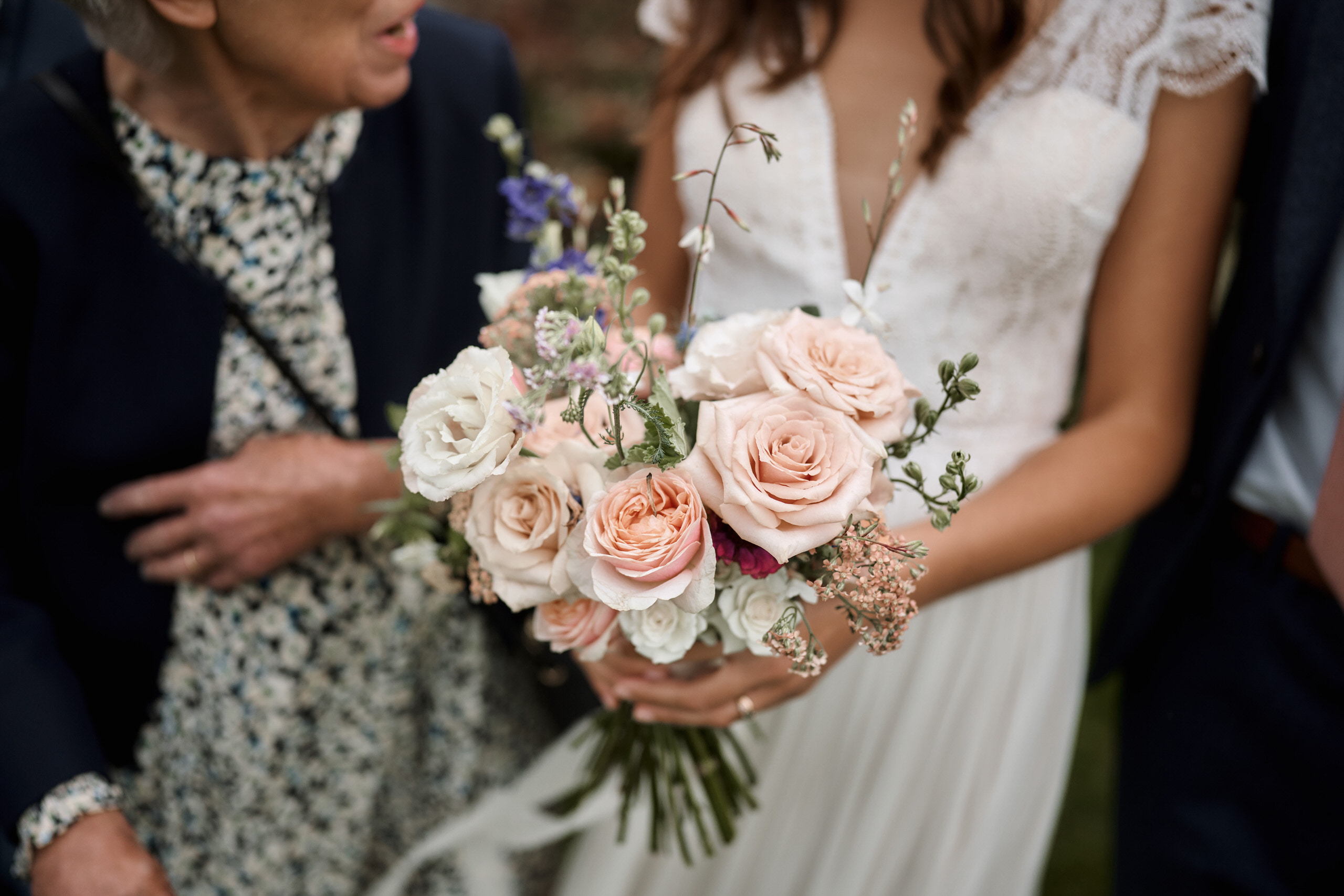 A woman is holding flowers in front of an older lady.