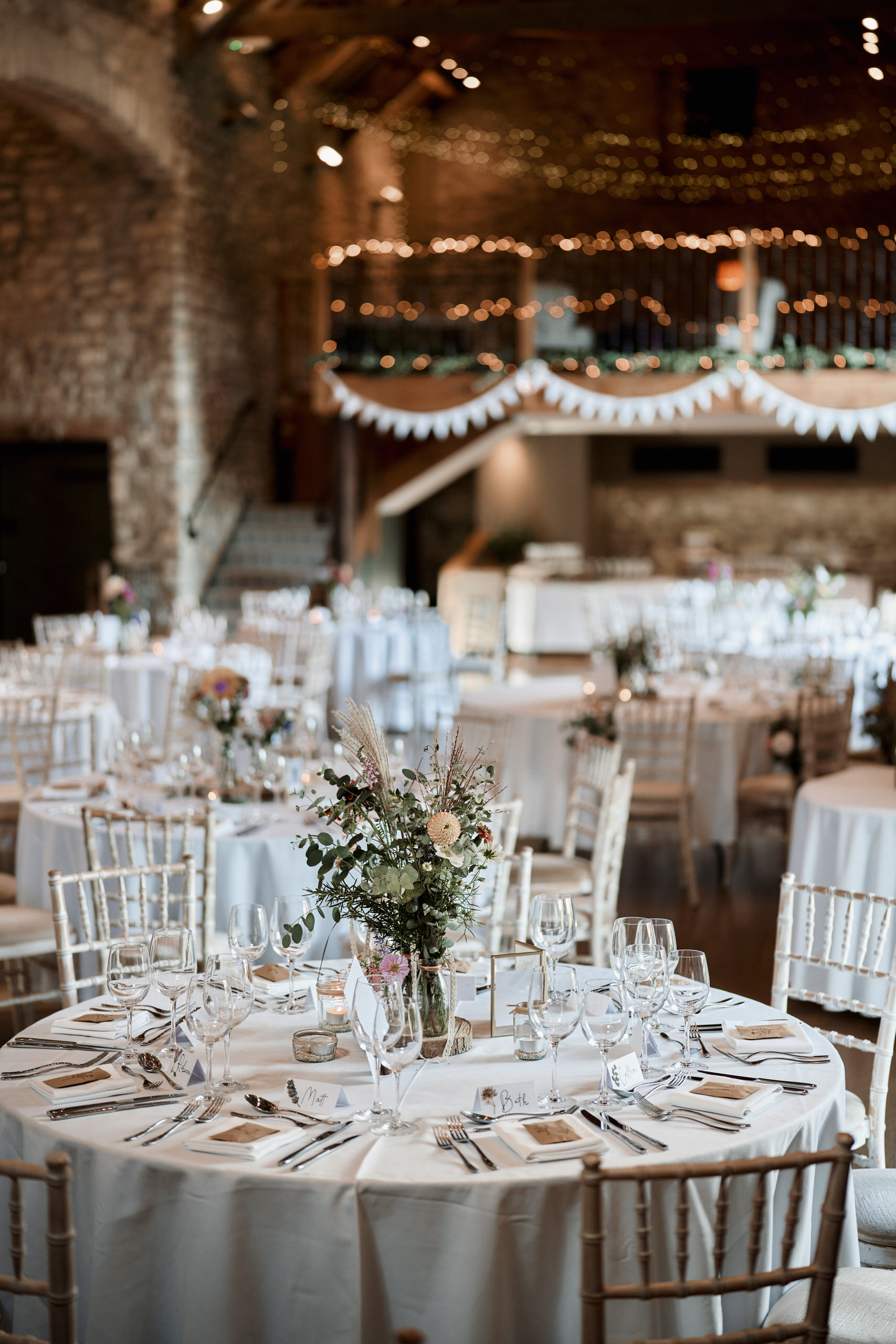 A barn party after a wedding with white tables and chairs.