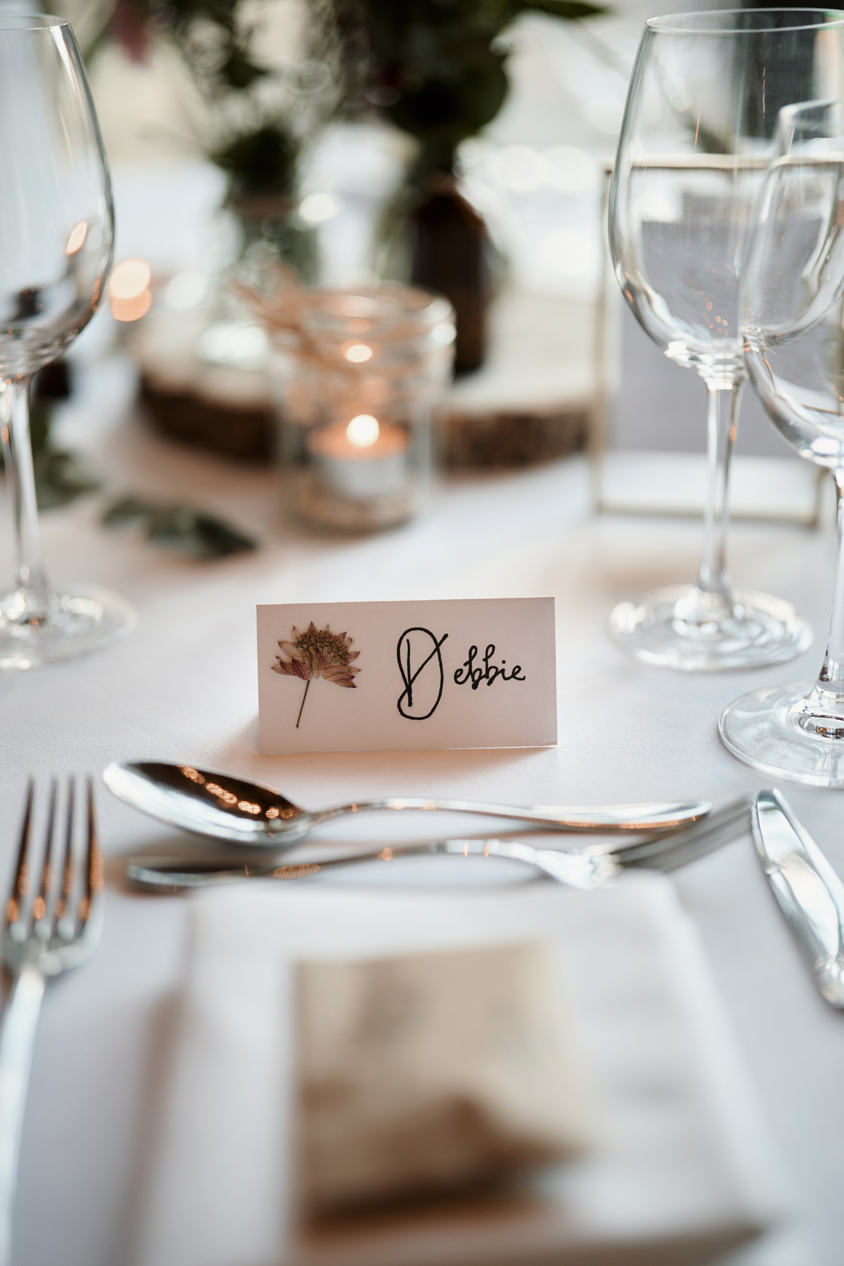 A dinner table setup that includes a name card and wine glasses.