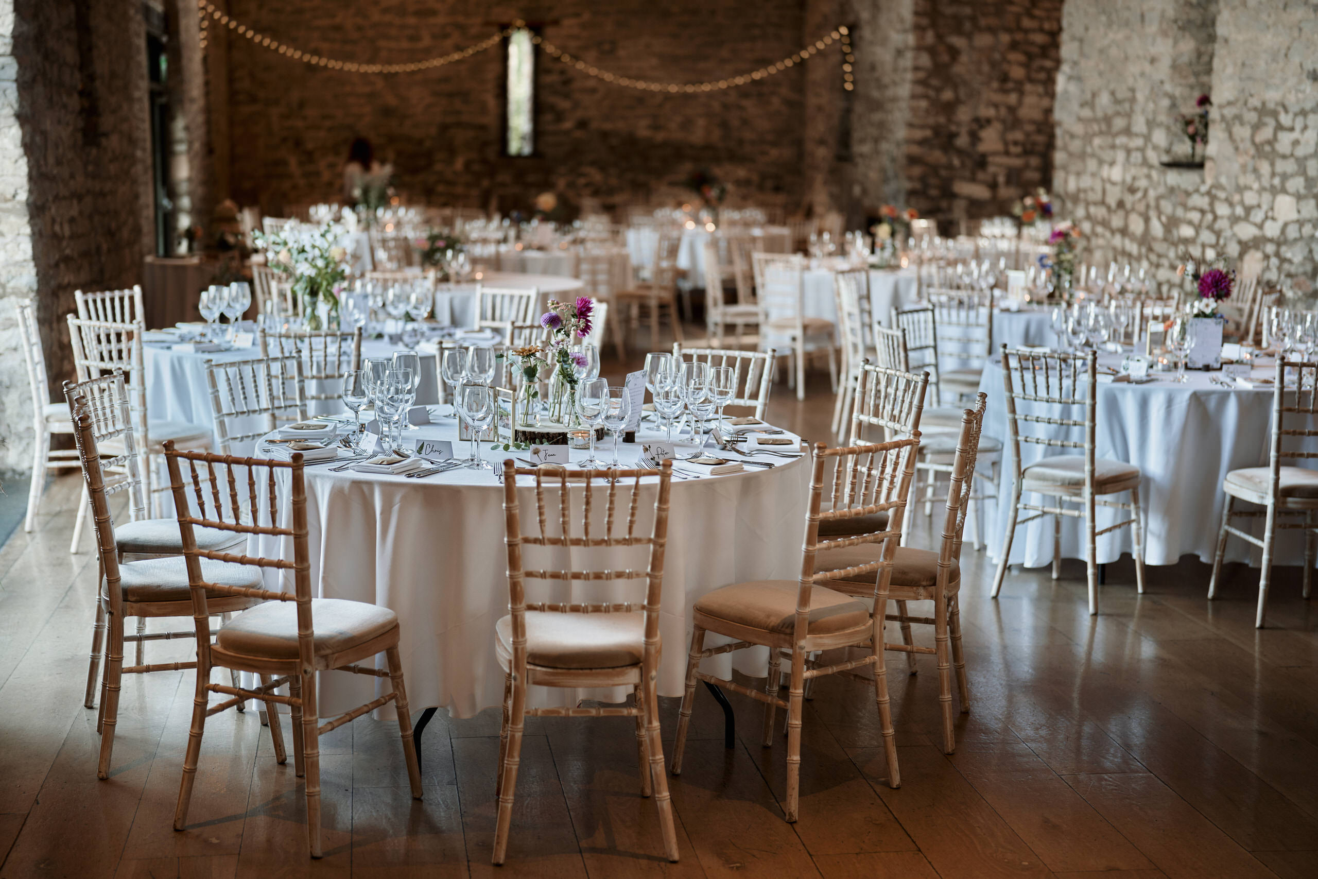 A big room set up with tables and chairs for a wedding party.