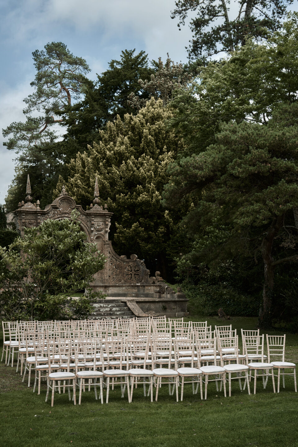A wedding is being arranged in a garden and chairs are set up.