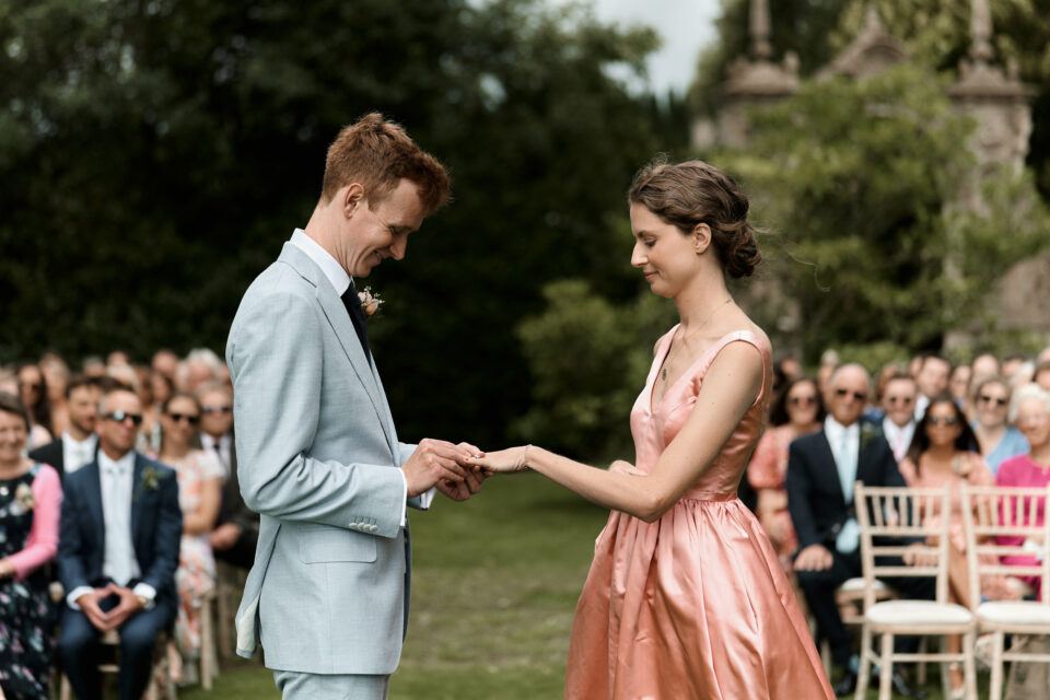 A man and woman give each other rings at their wedding.