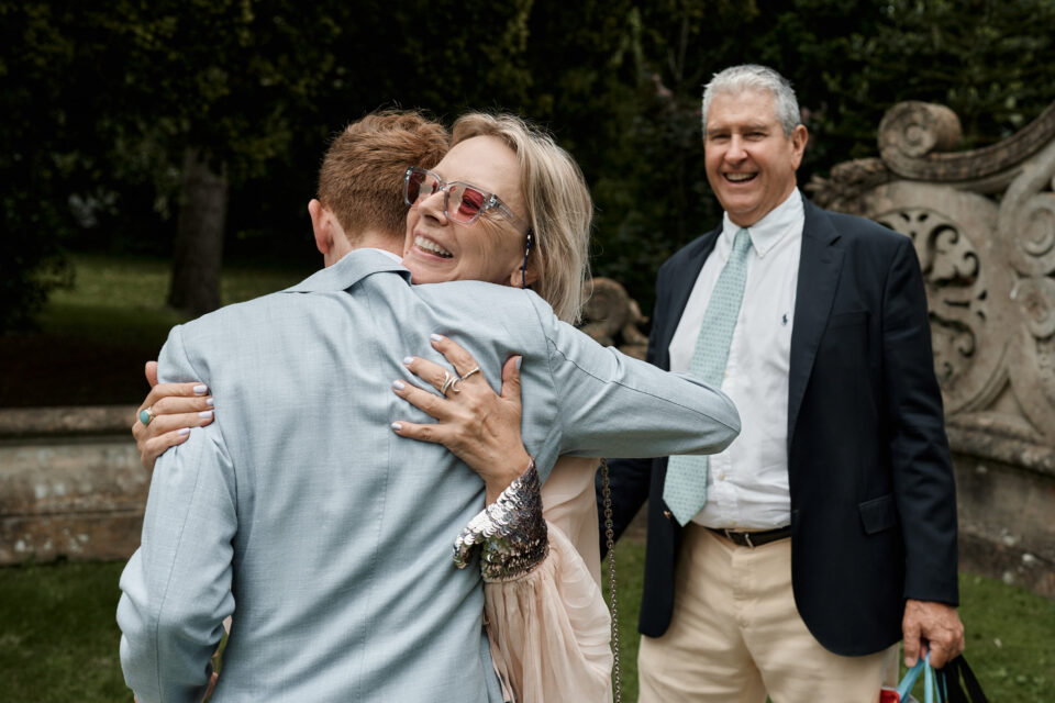 A lady is giving a hug to a guy in a suit.