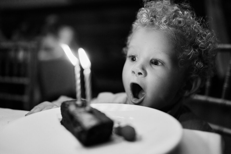 Picture of a young boy with his birthday cake in black and white.