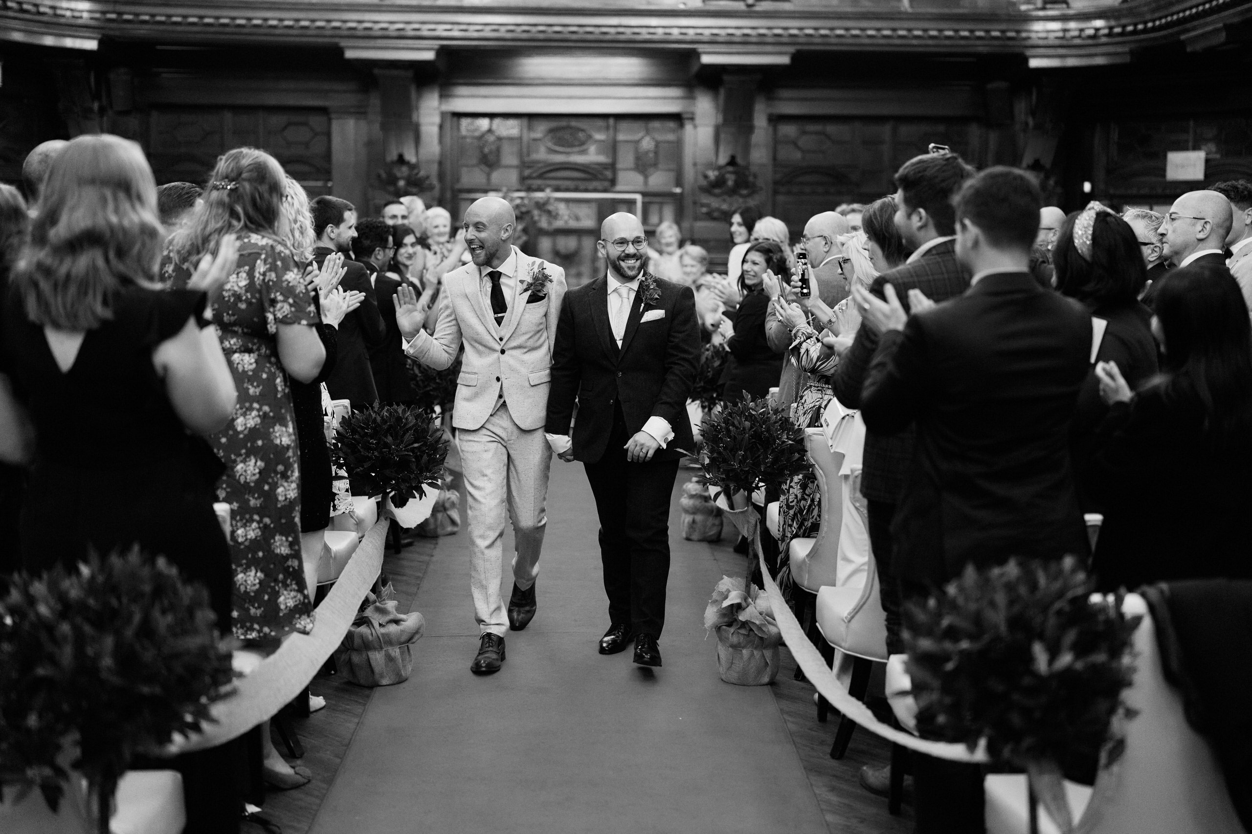 A picture in black and white of a pair strolling down the aisle.