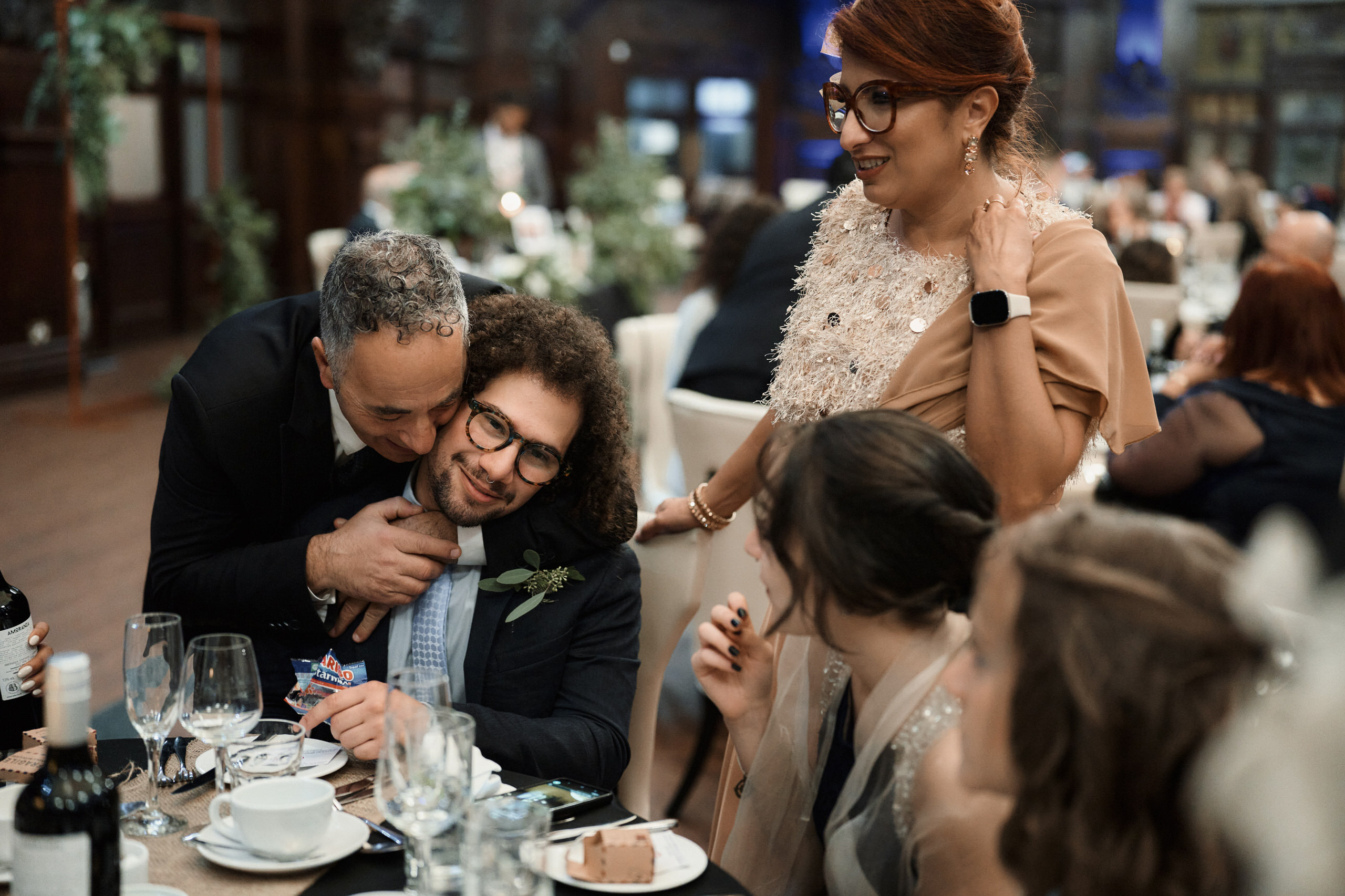 A guy is giving a lady a hug at a wedding party.