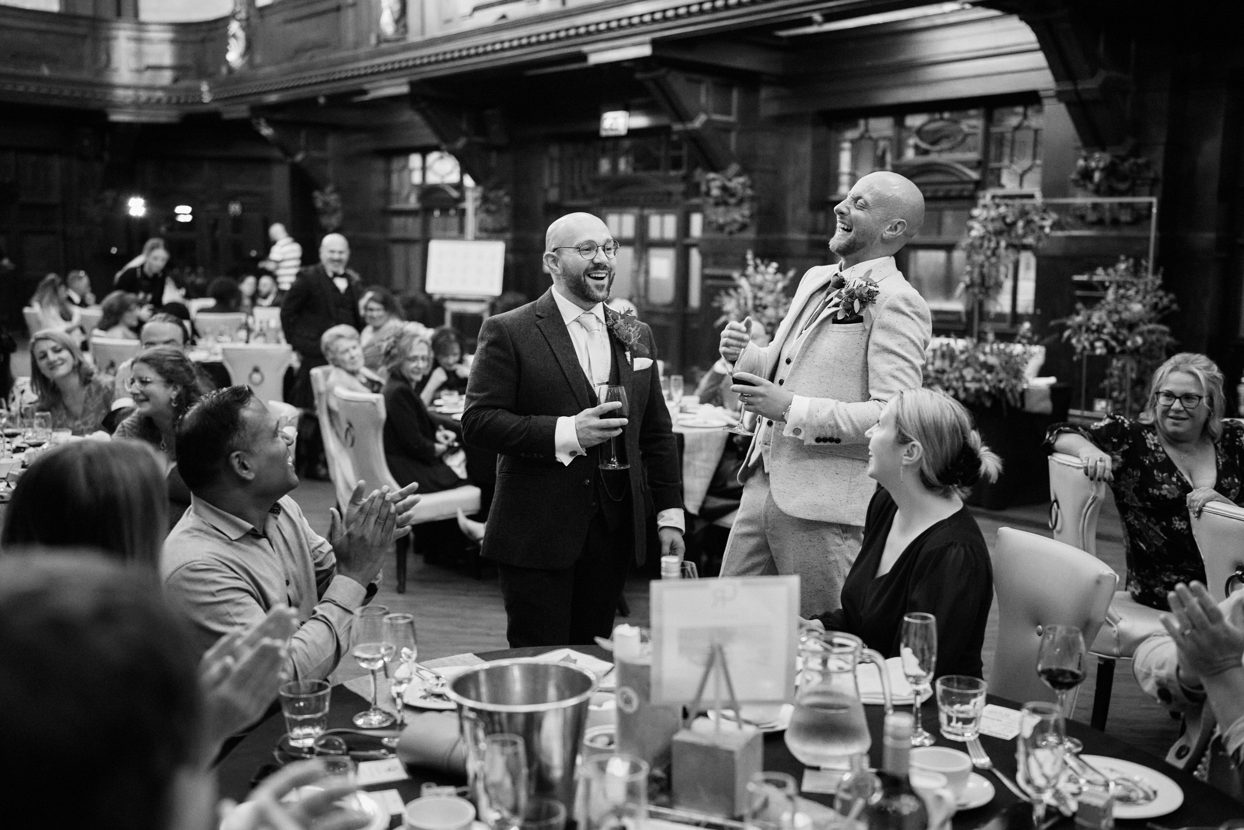 A grayscale picture of two guys at a wedding.