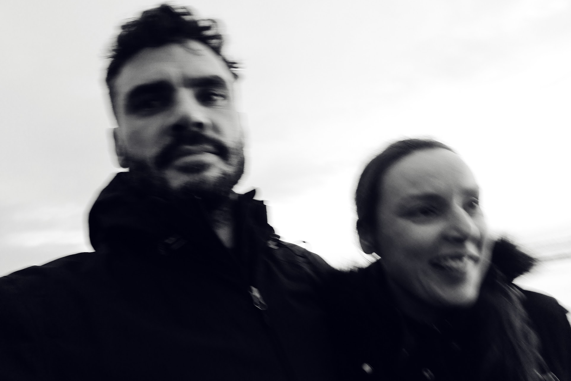 A man and woman are taking a selfie in a black and white picture.