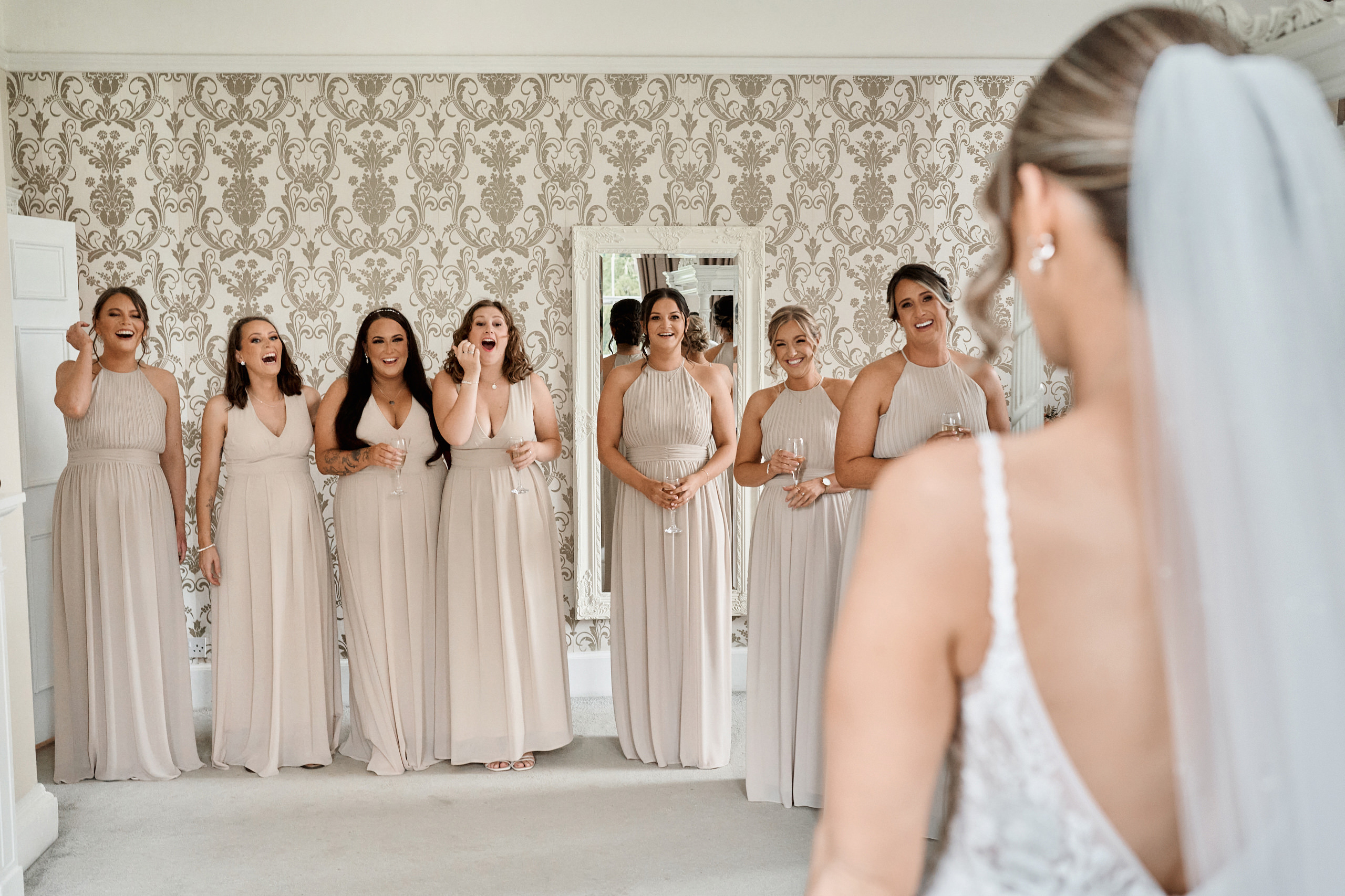 Bridesmaids looking at each other in the mirror.