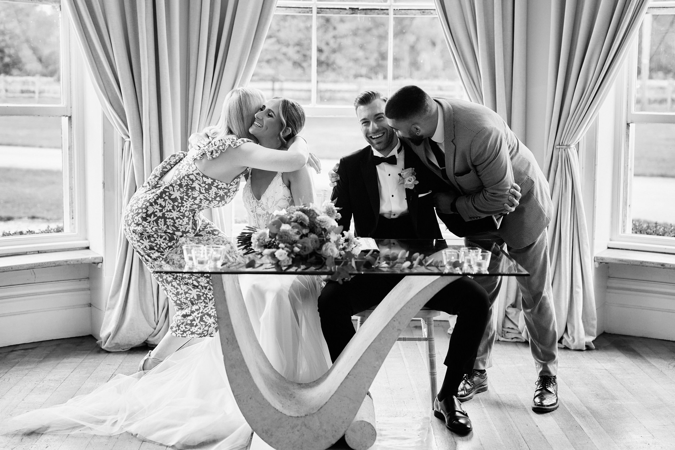 A bride and groom kissing at a table.