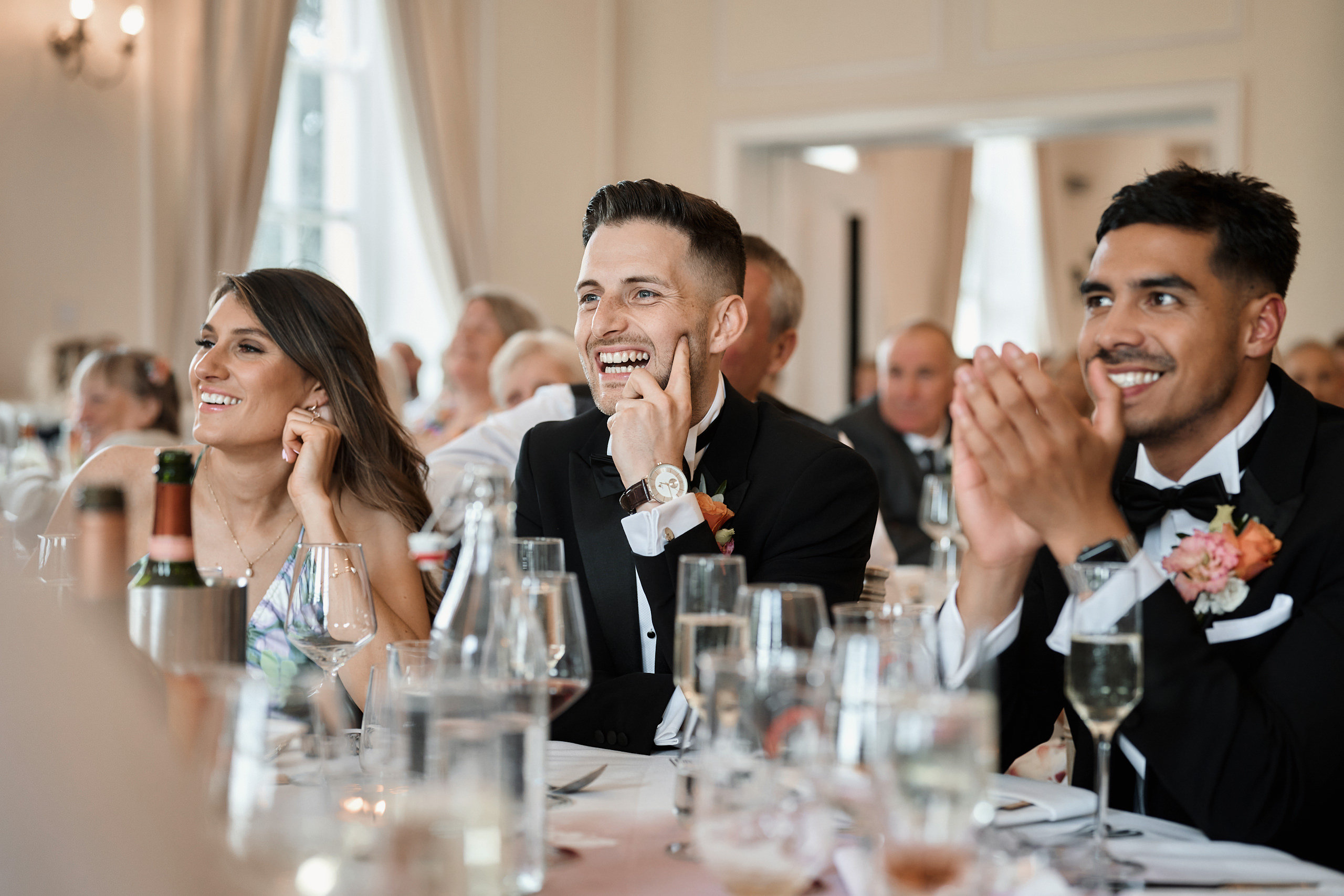 A group of people clapping at a wedding reception.