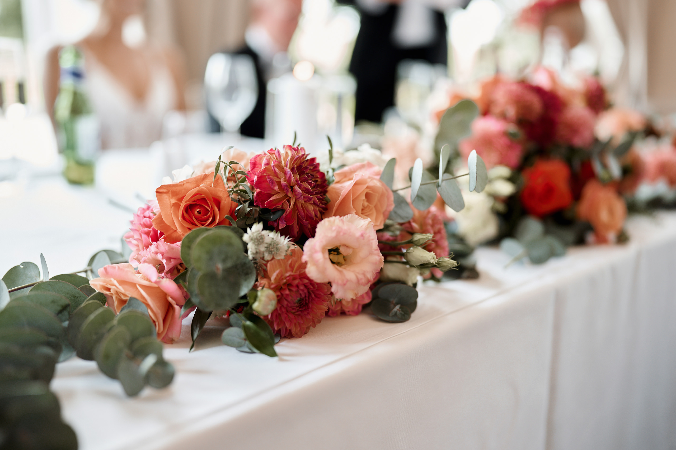 A table is decorated with pink and orange flowers.