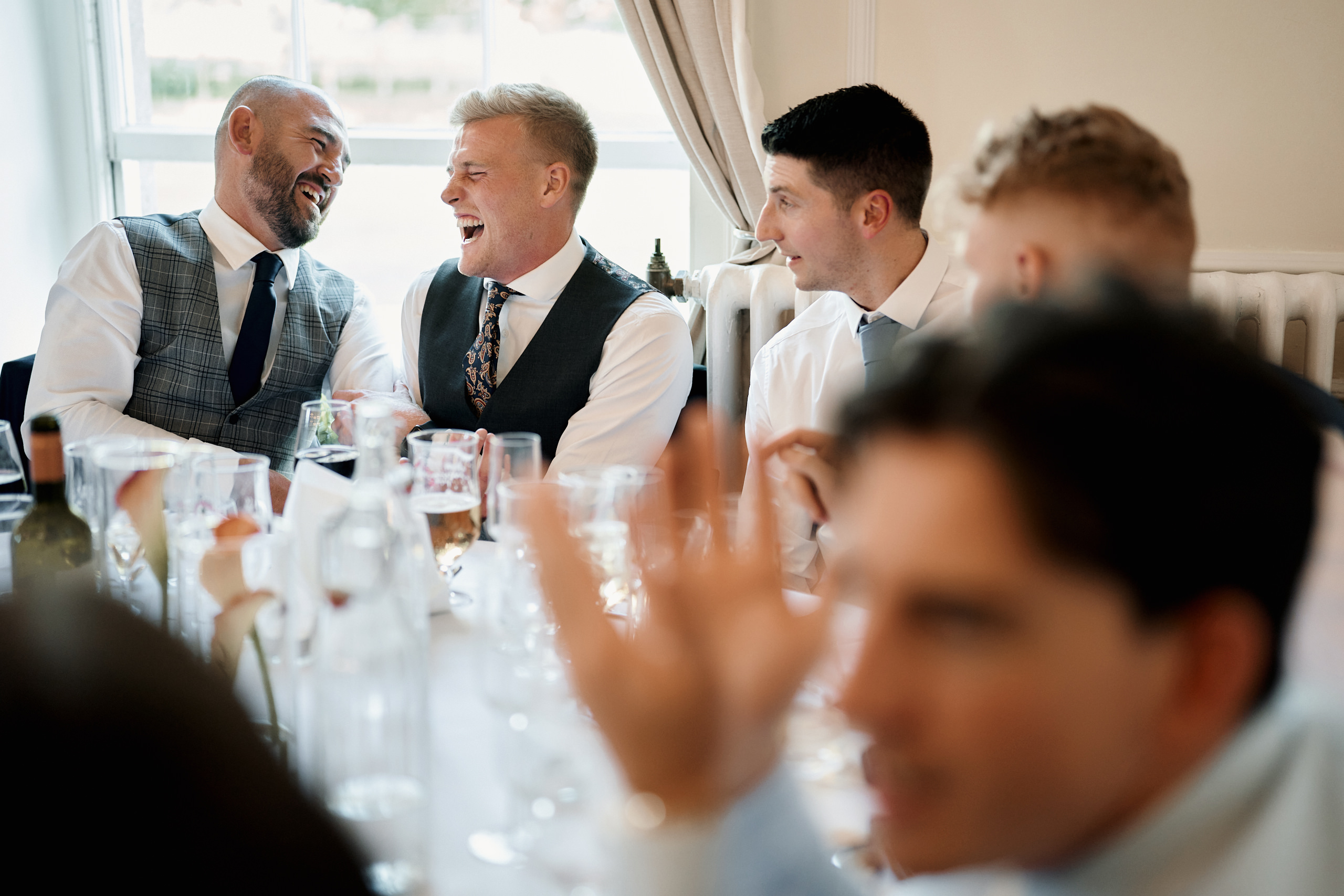 A group of men laughing at a table.