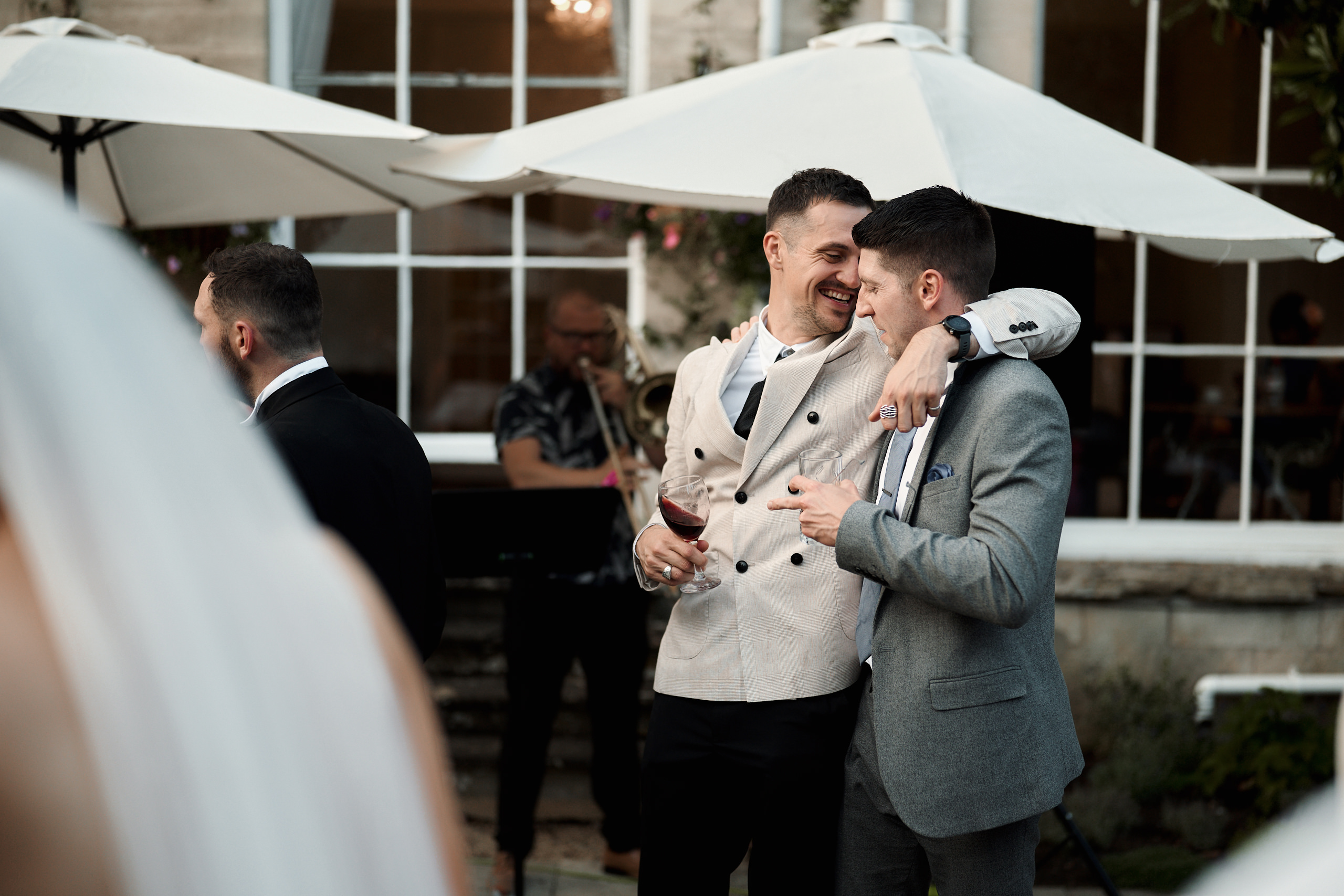 Two men hugging at a wedding reception.