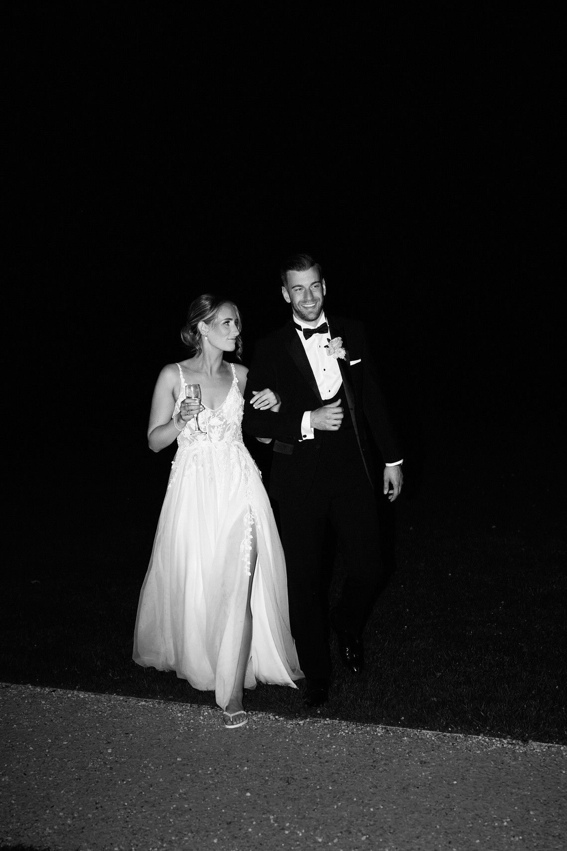 An Eastington Park wedding, with the bride and groom gracefully walking down a path at night.