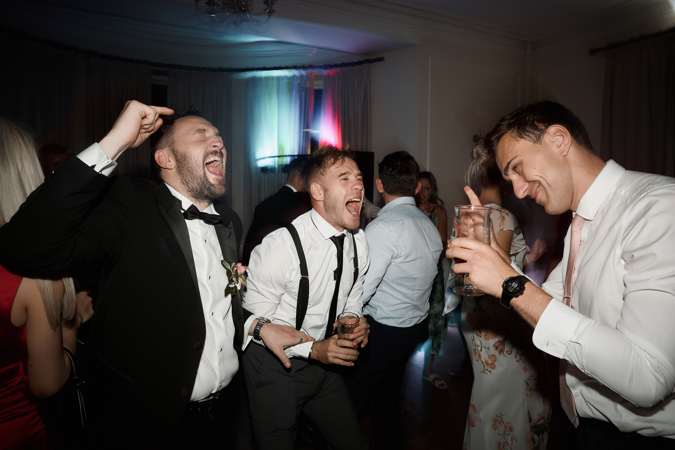 A group of men laughing at an Eastington Park wedding party.