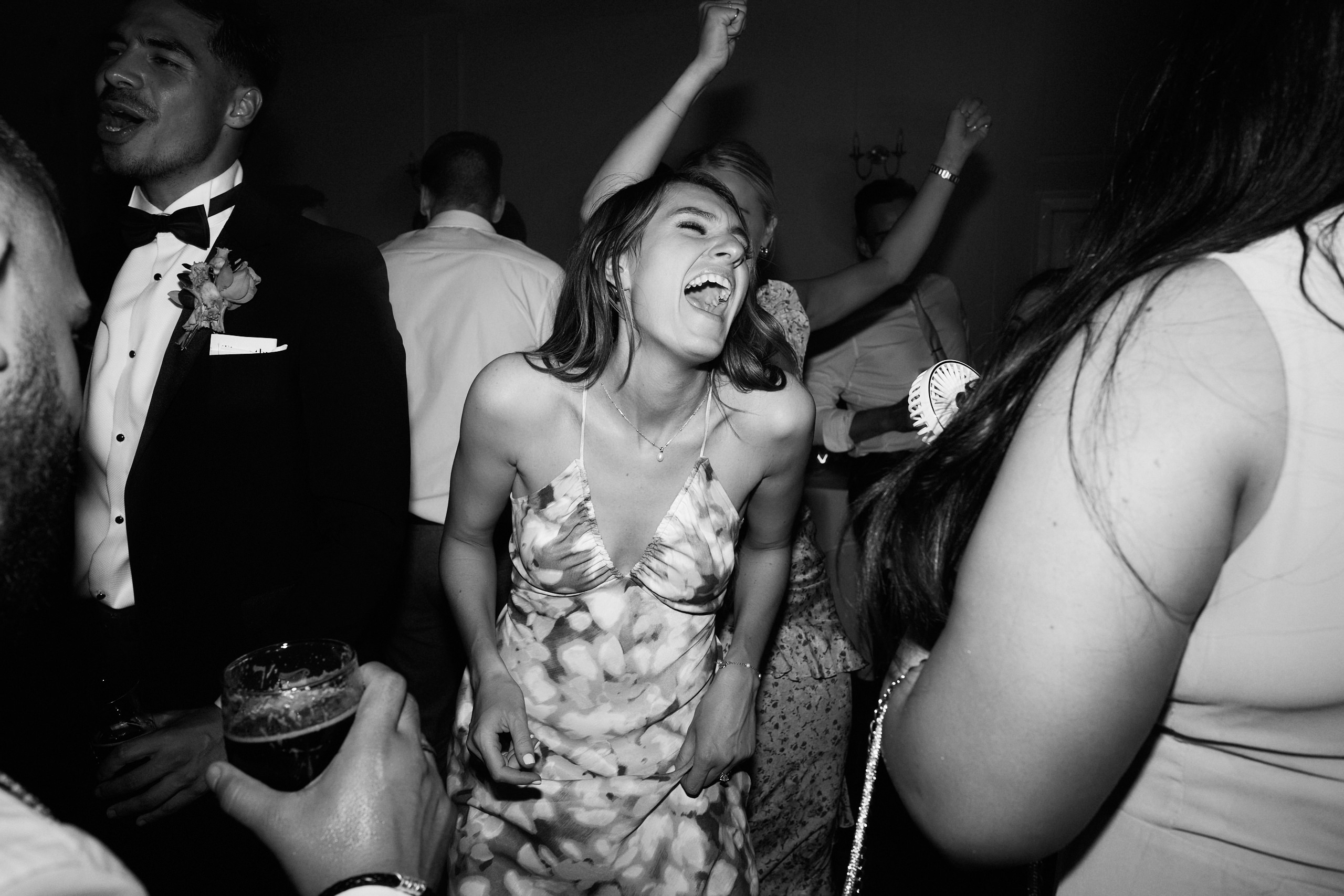 Black and white photo of a group of people dancing on the dance floor.