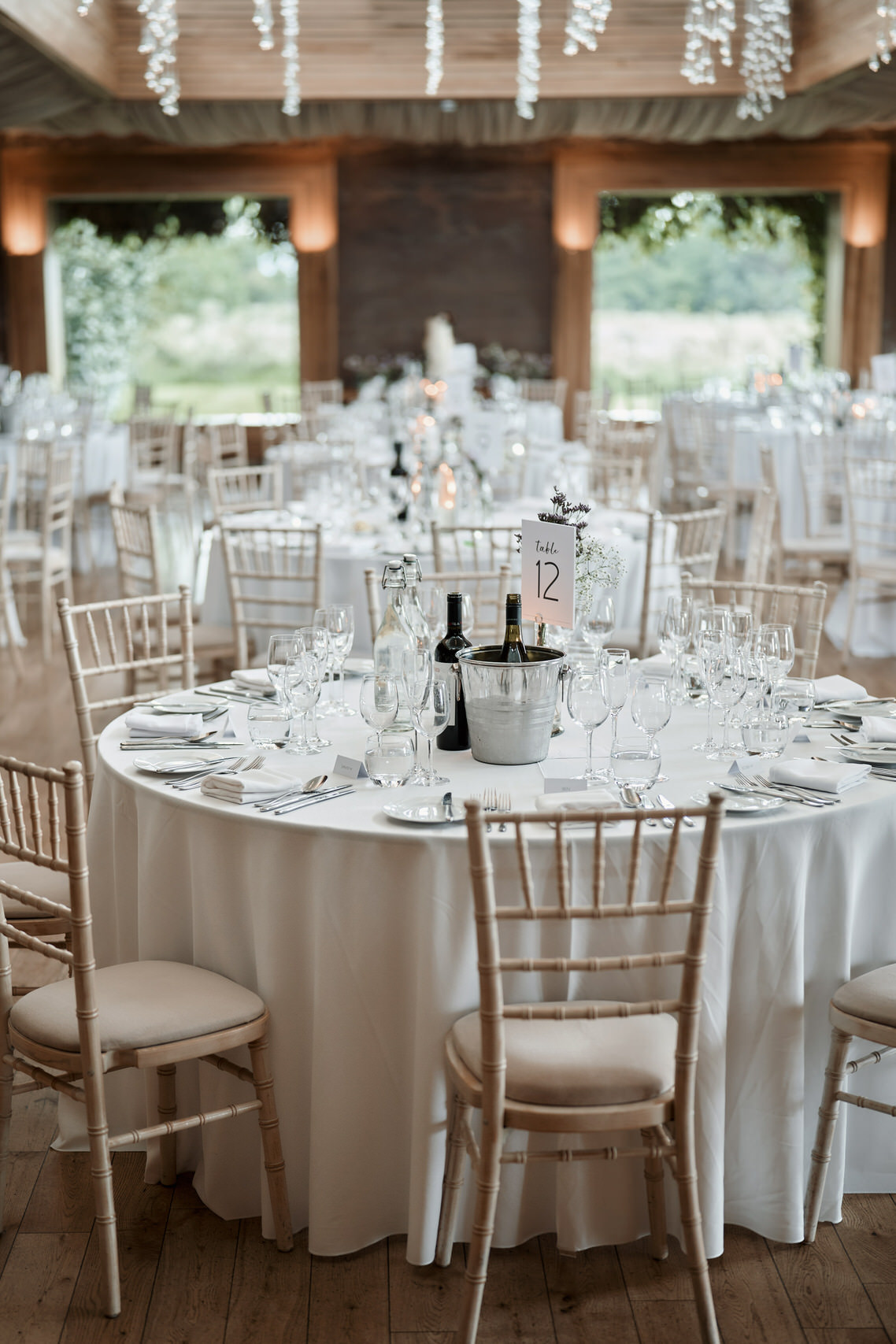 A wedding party area arranged with white tables and chairs.
