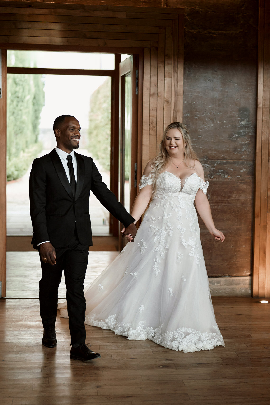 A couple getting married are holding hands in a room with wood walls.