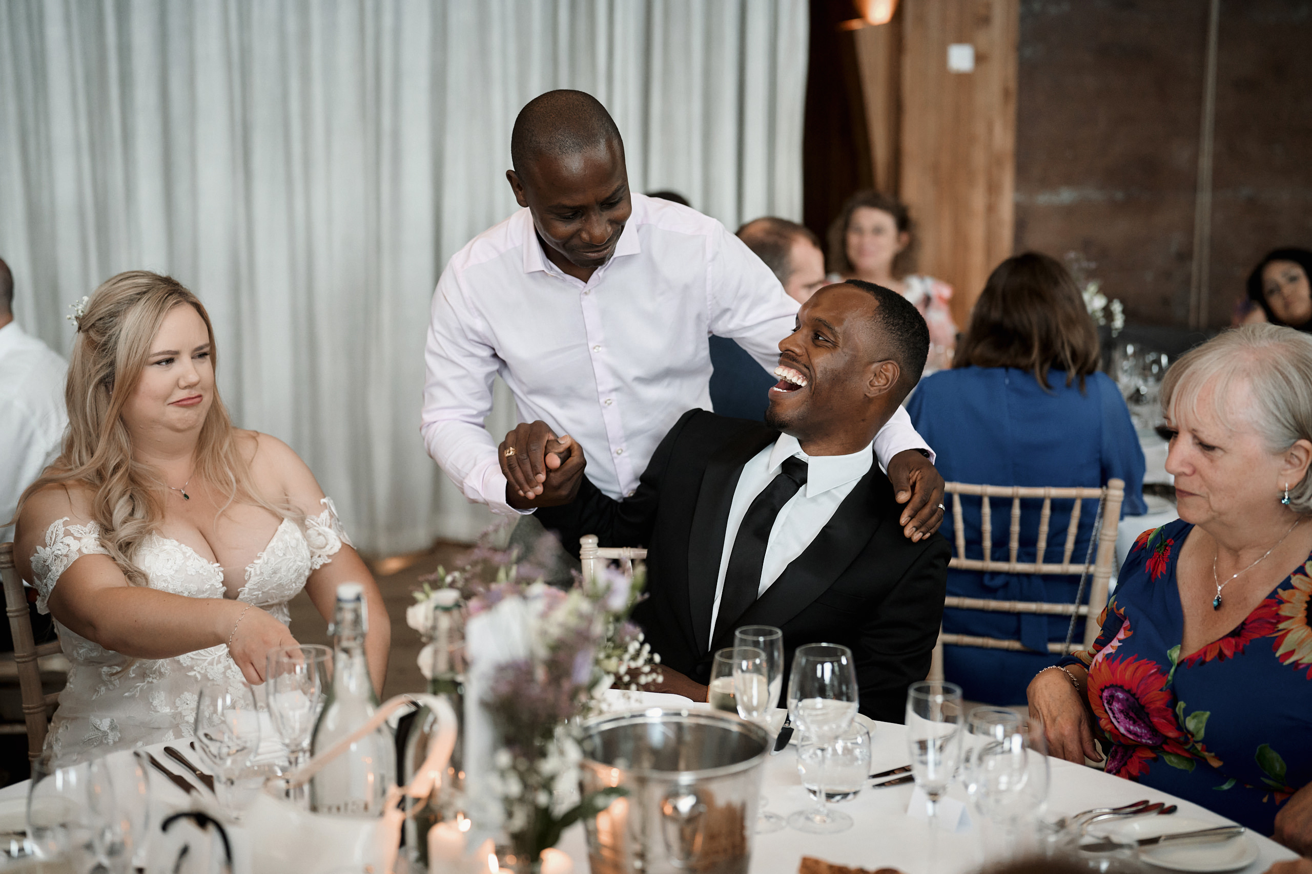 A couple is chuckling at their wedding party.