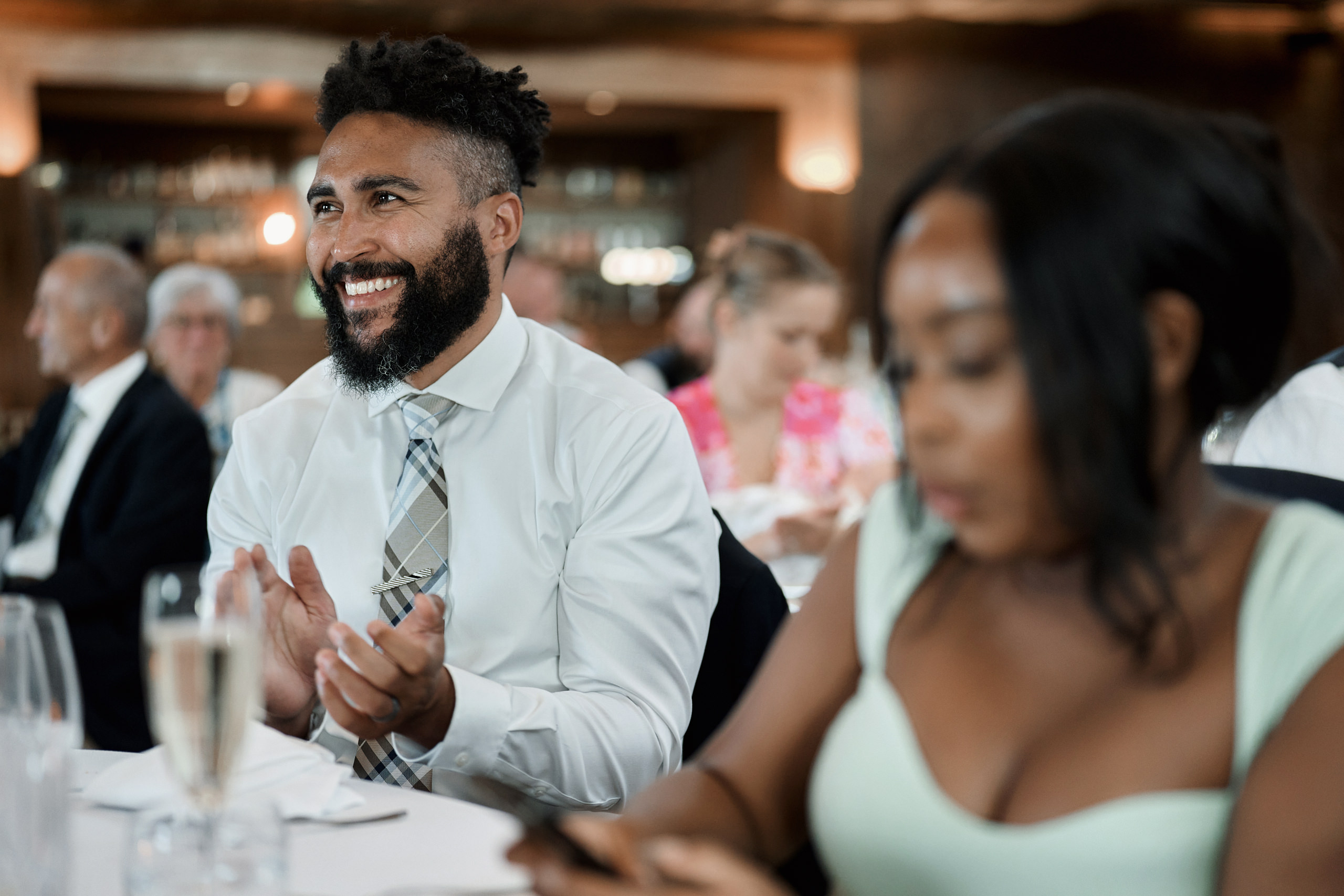 A guy and a girl applauding at a wedding party.