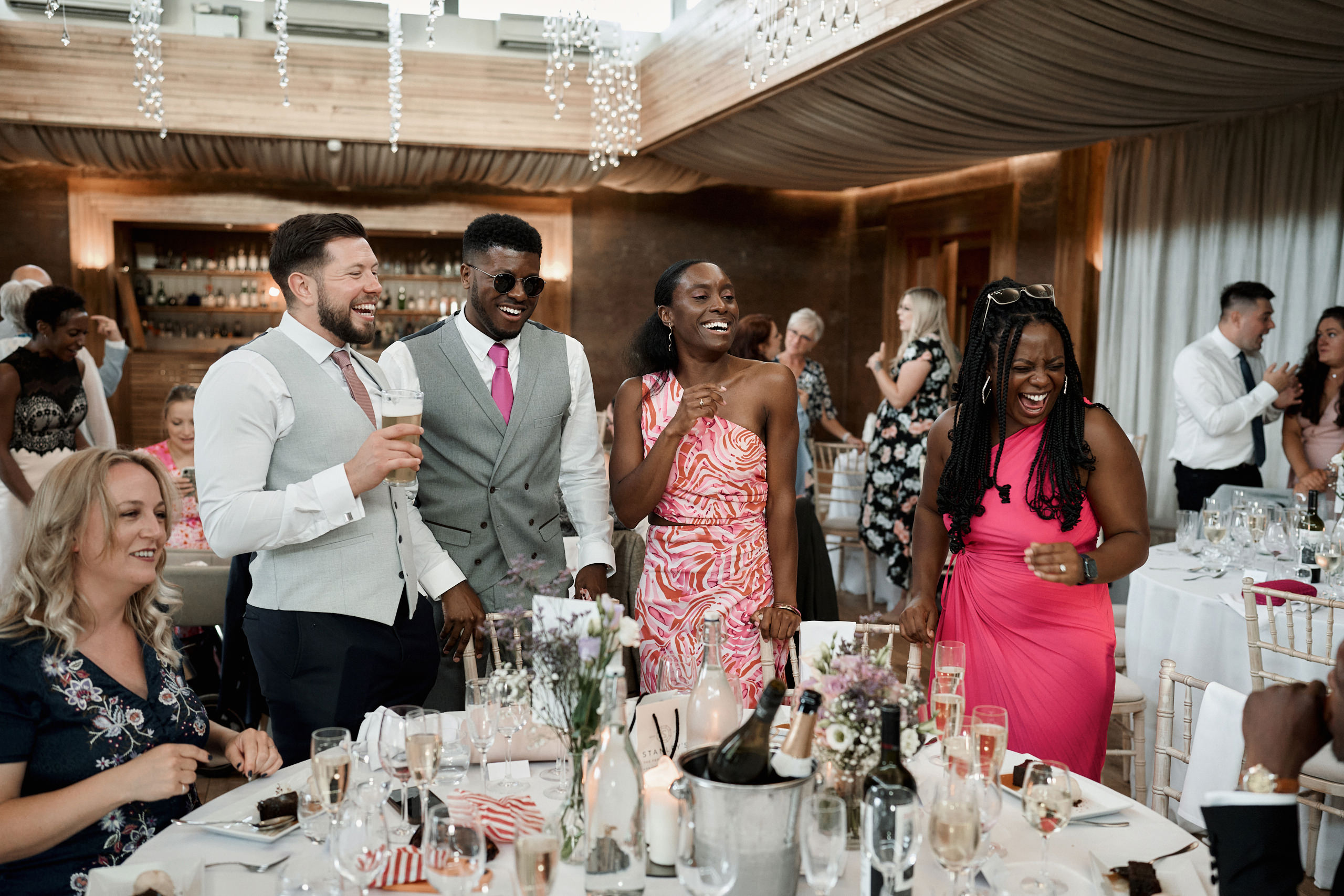People are cracking up at a wedding party.