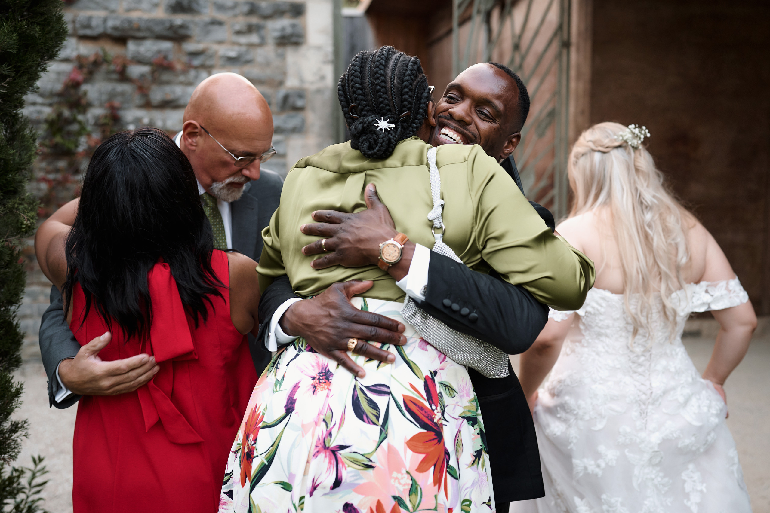 A couple getting married are hugging in front of a crowd.