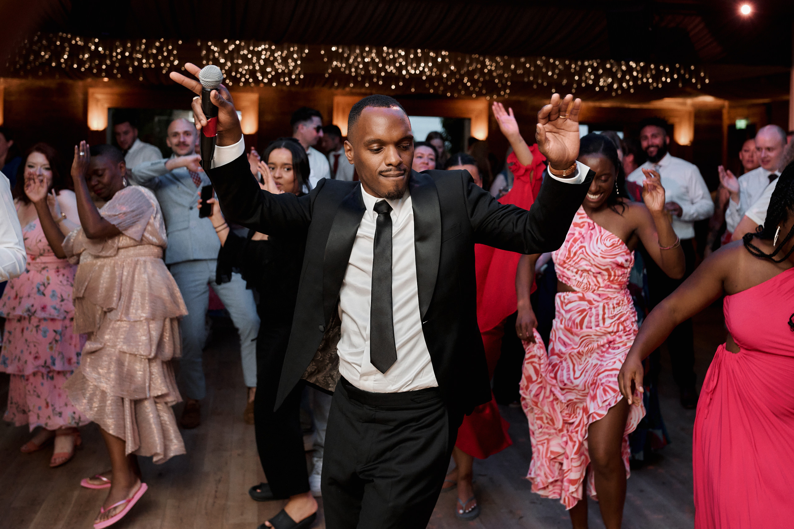 A guy in a suit busting a move at a wedding party.