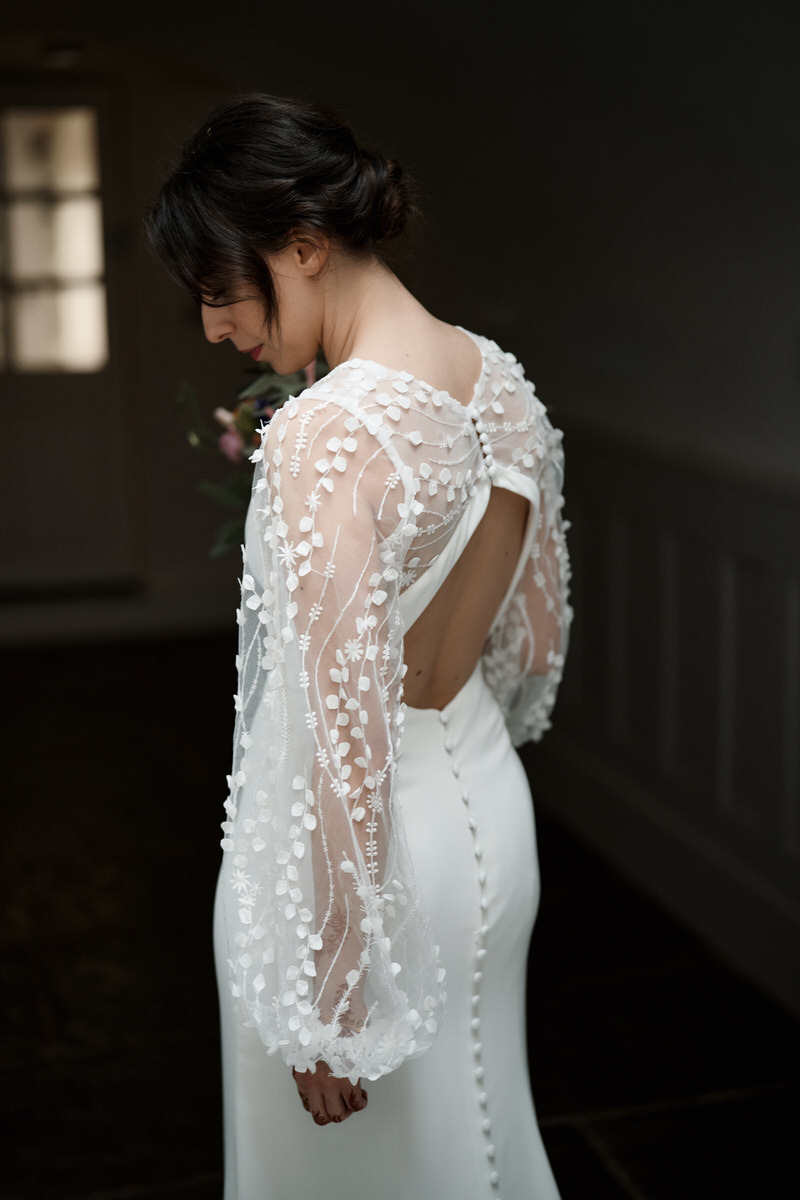 The back view of a bride wearing a white wedding dress.