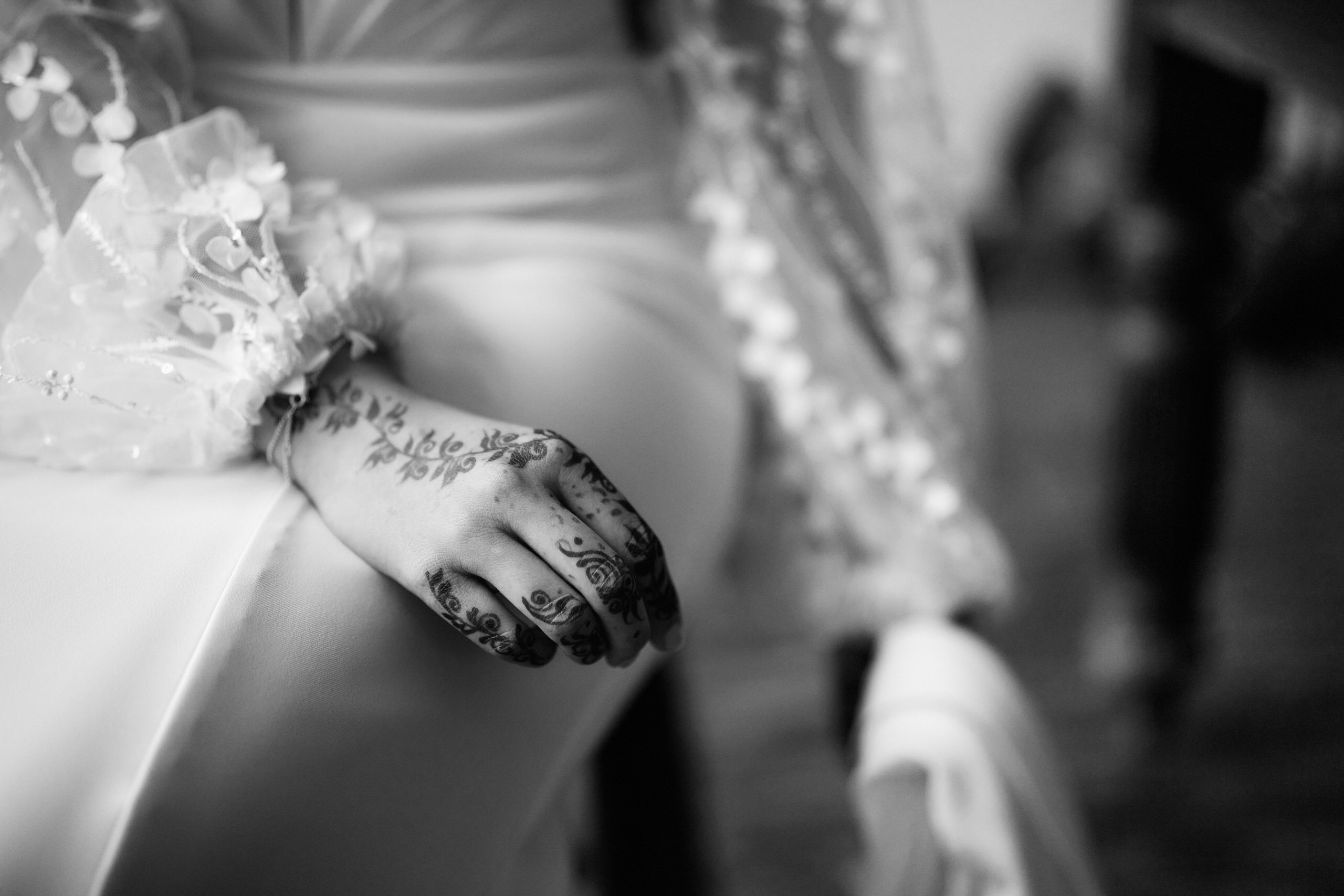 A picture in black and white of a bride's hand decorated with henna designs.