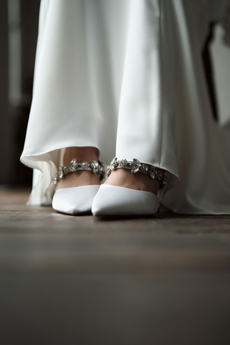 Wedding shoes of a bride on a wooden floor.