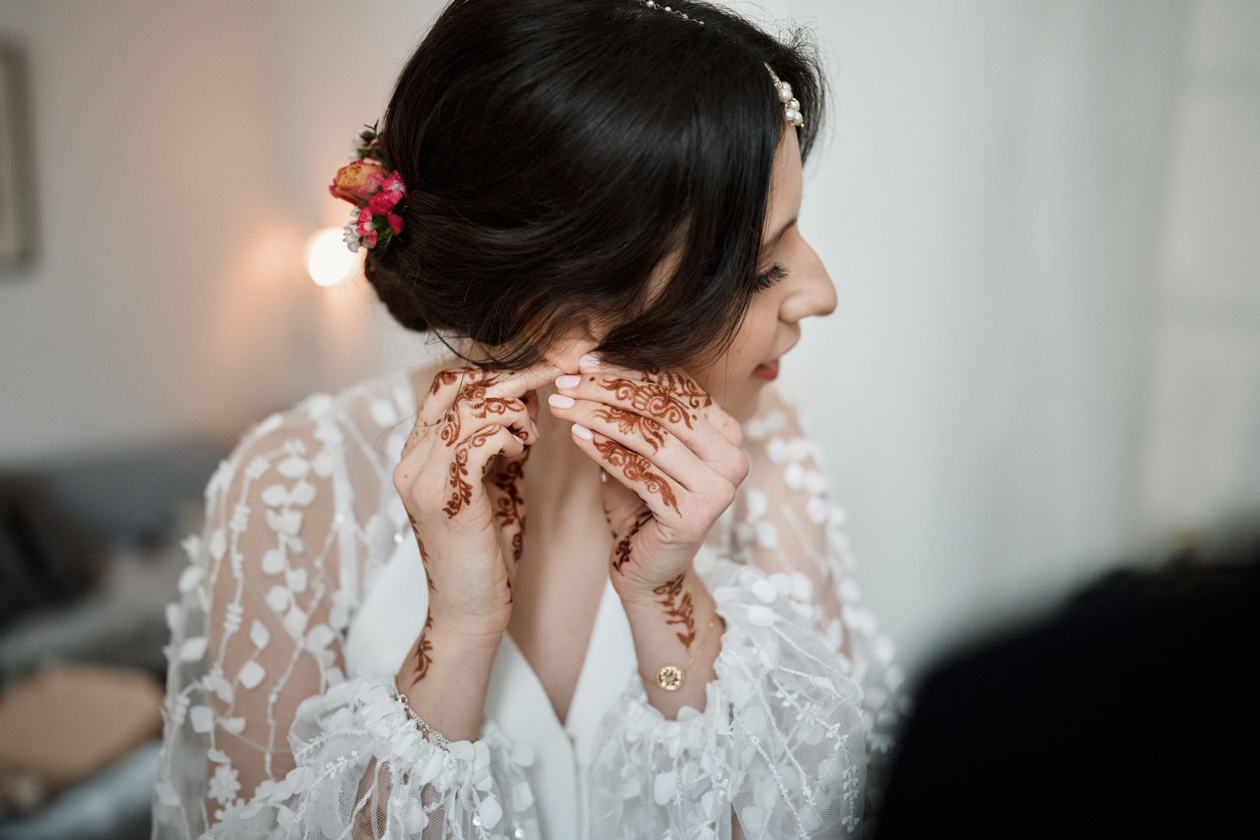 A bride is applying henna to her face.