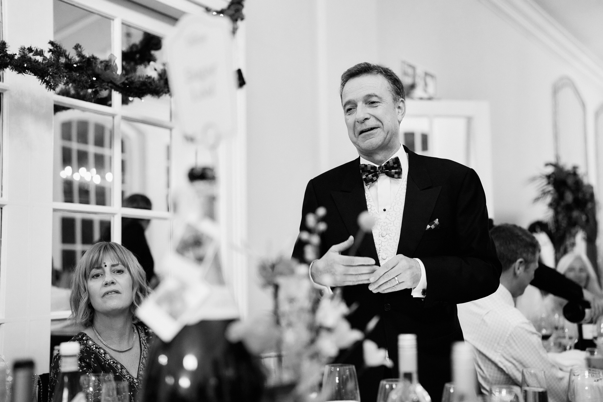 A guy in a suit talking at a wedding.