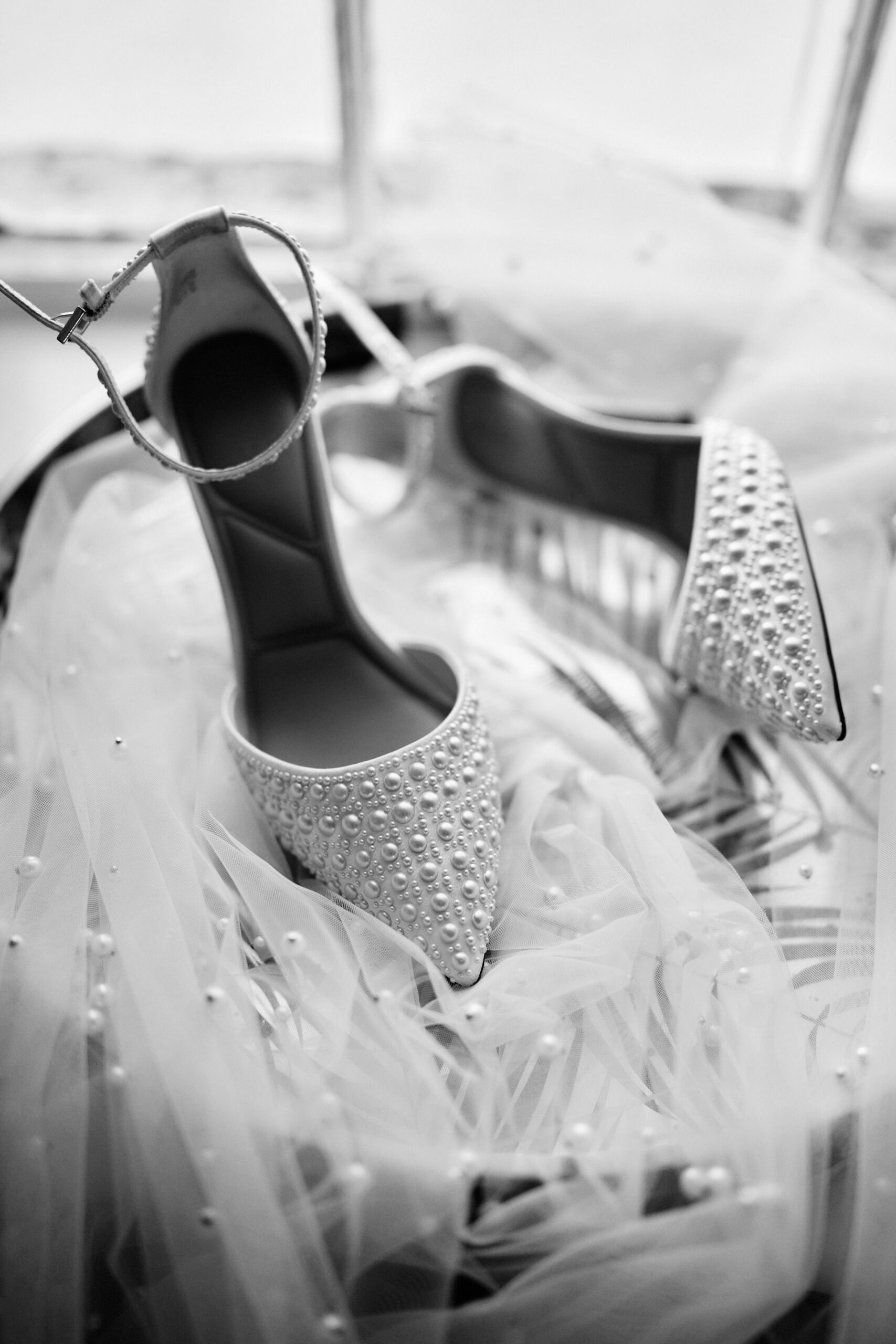 A picture in black and white of a couple's wedding shoes.