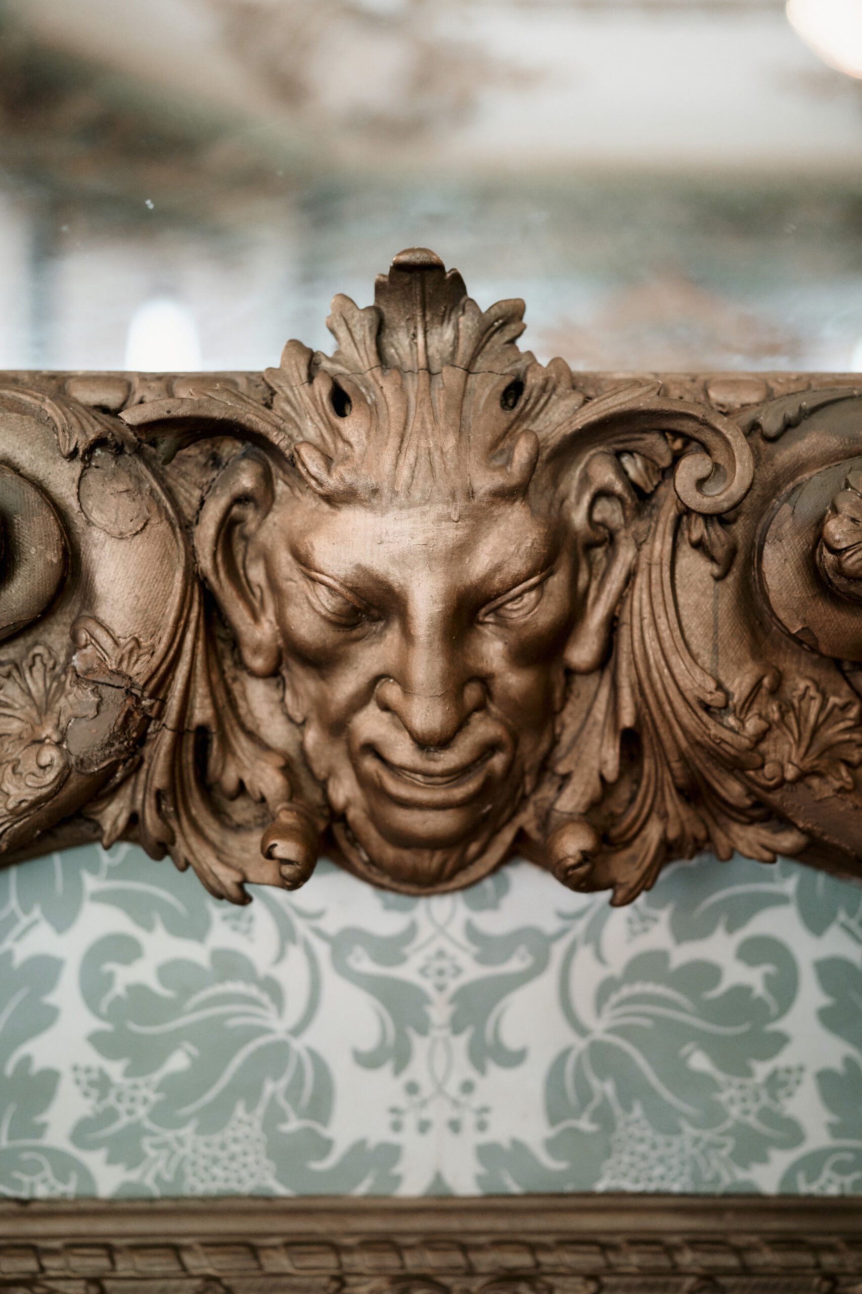A fancy carved face on a wall.