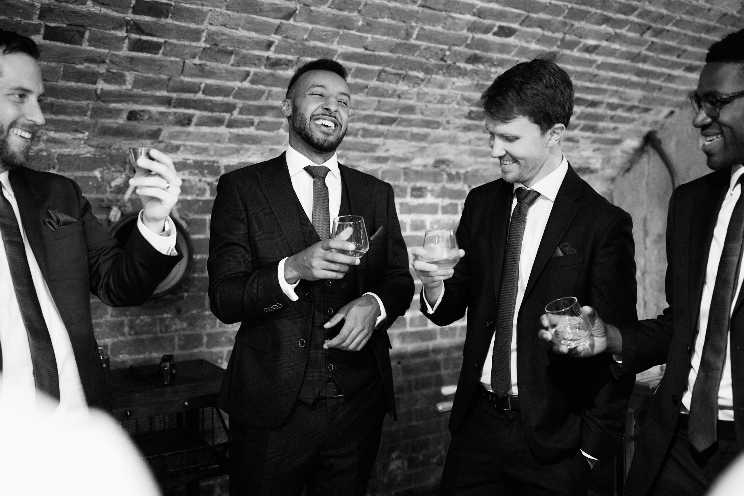 A black and white picture showing a bunch of guys in suits.