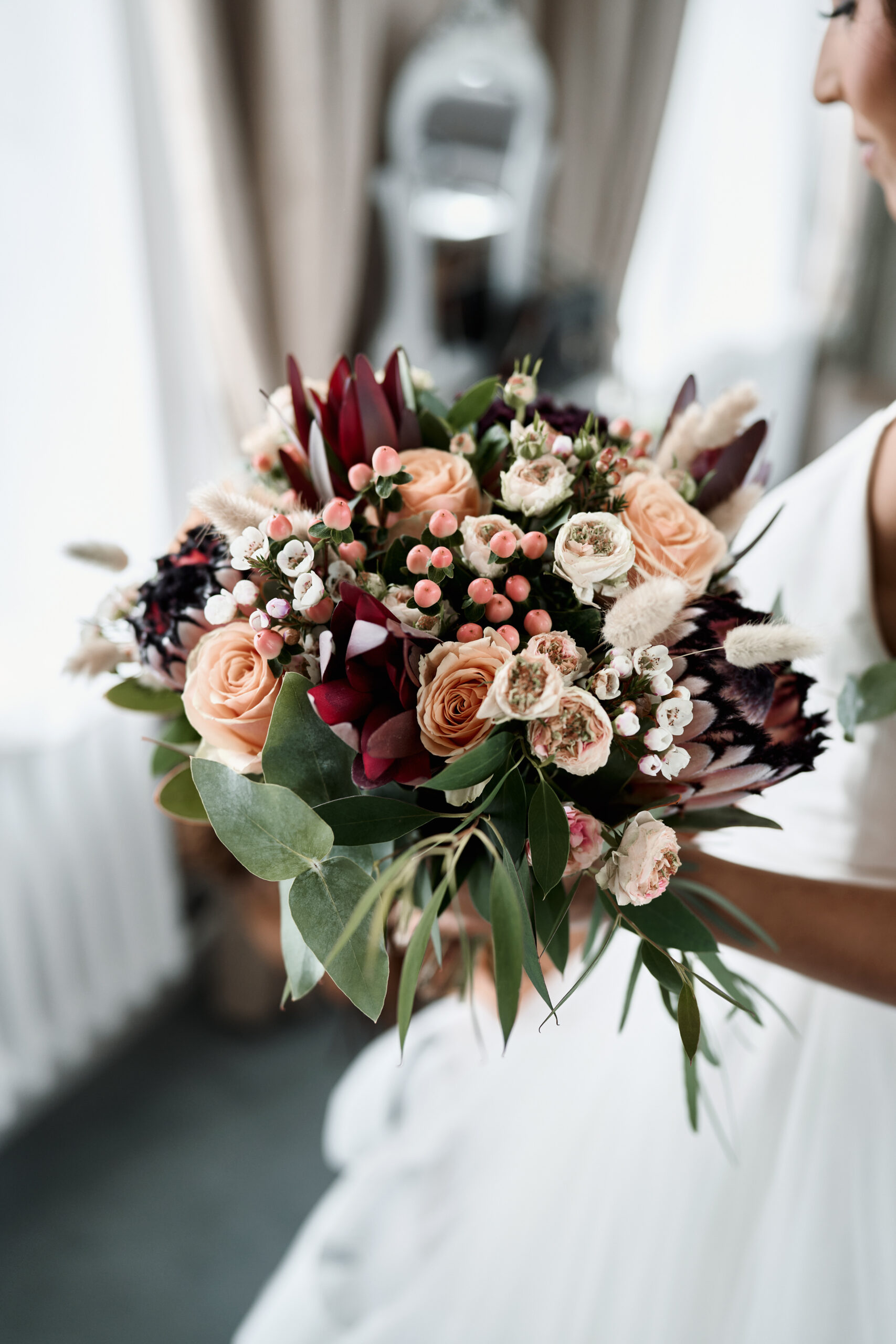 A woman getting married holding a bunch of flowers.