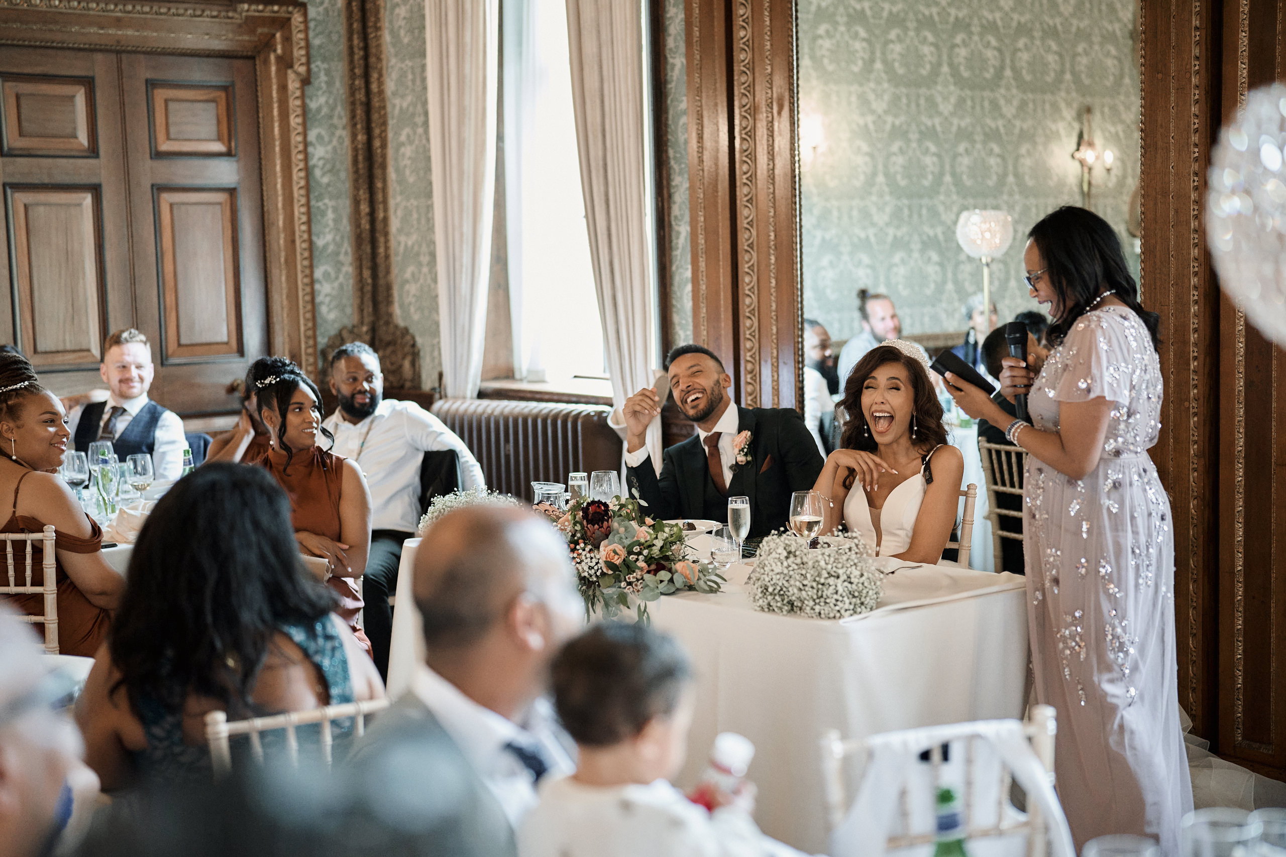 A man and woman giving a speech at a wedding party.