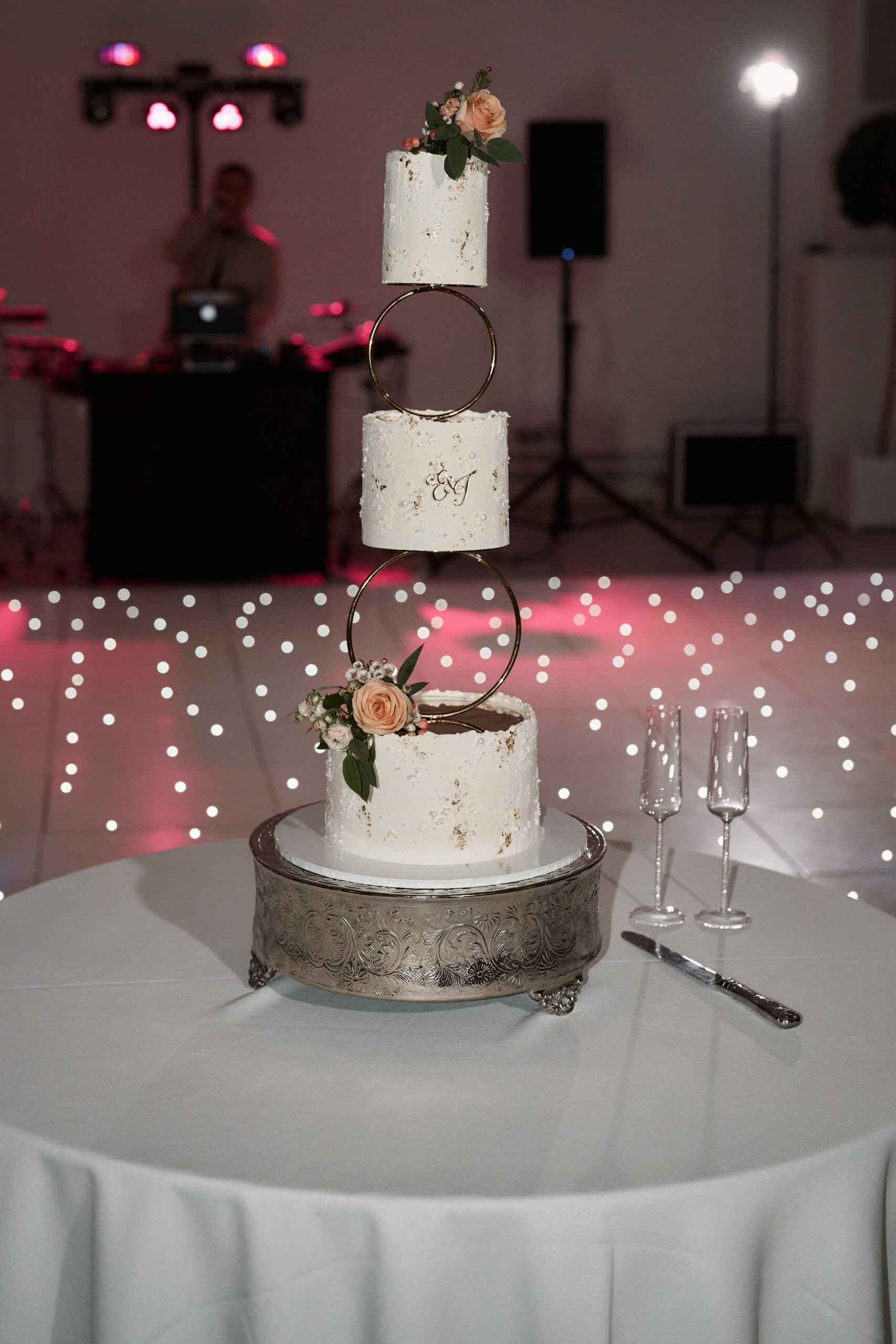 A three-layer wedding cake is sitting on a table.