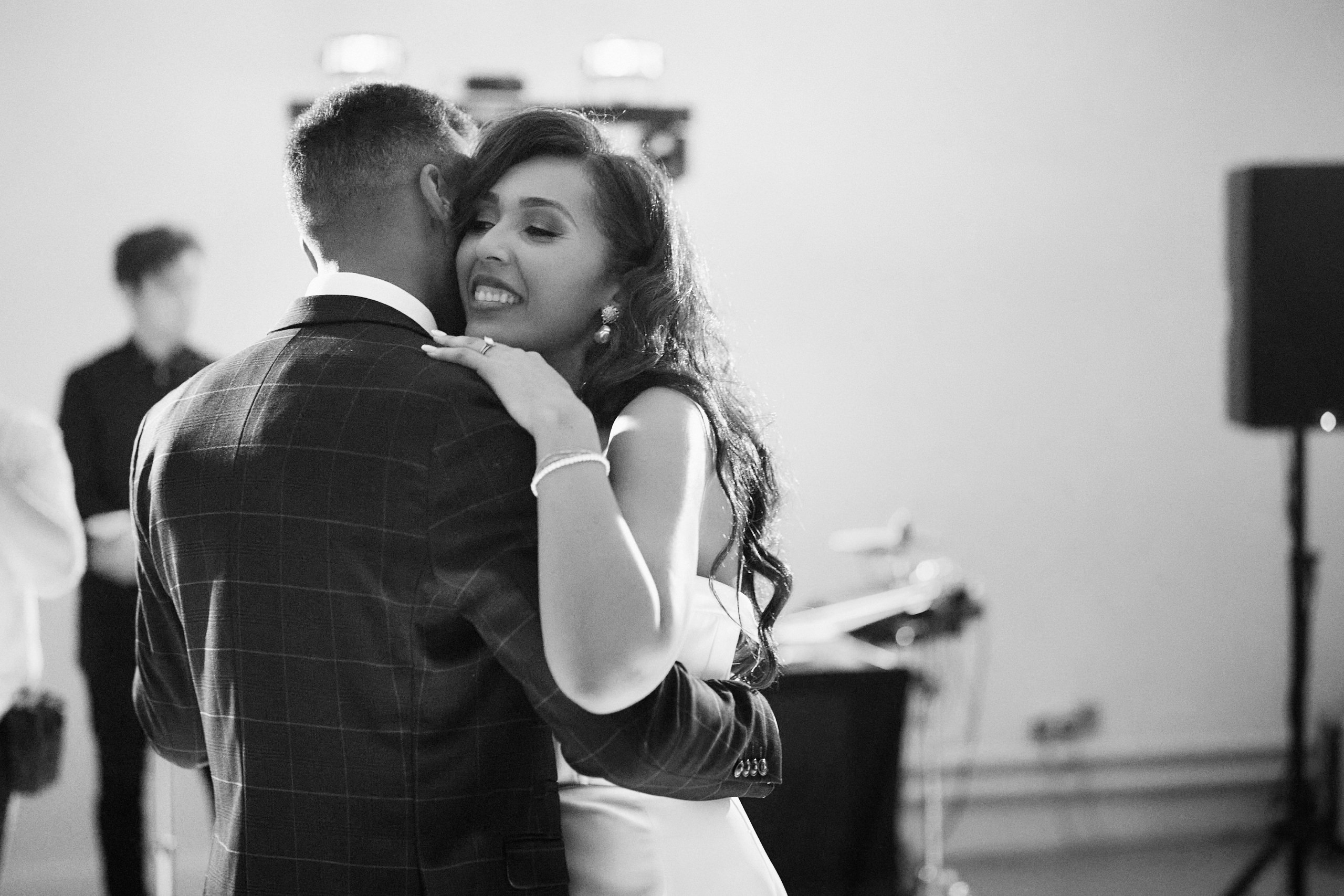 A couple is hugging while having their first dance at their wedding.