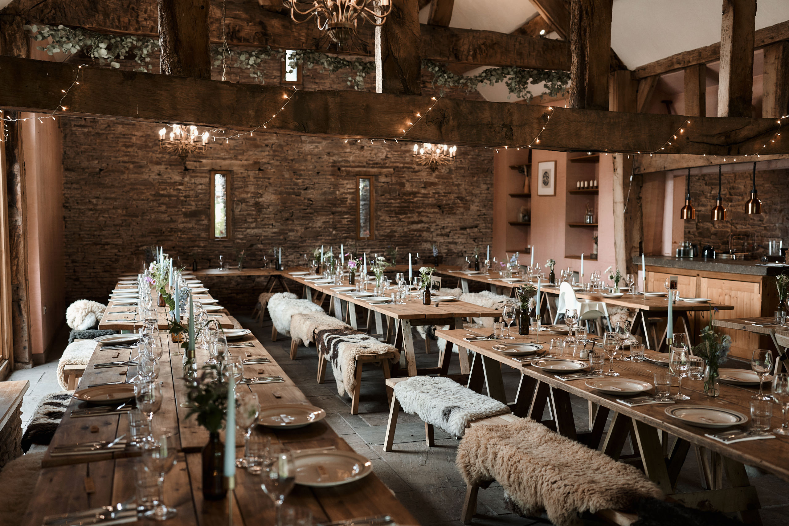 A simple country-style barn wedding with wooden tables and chairs.
