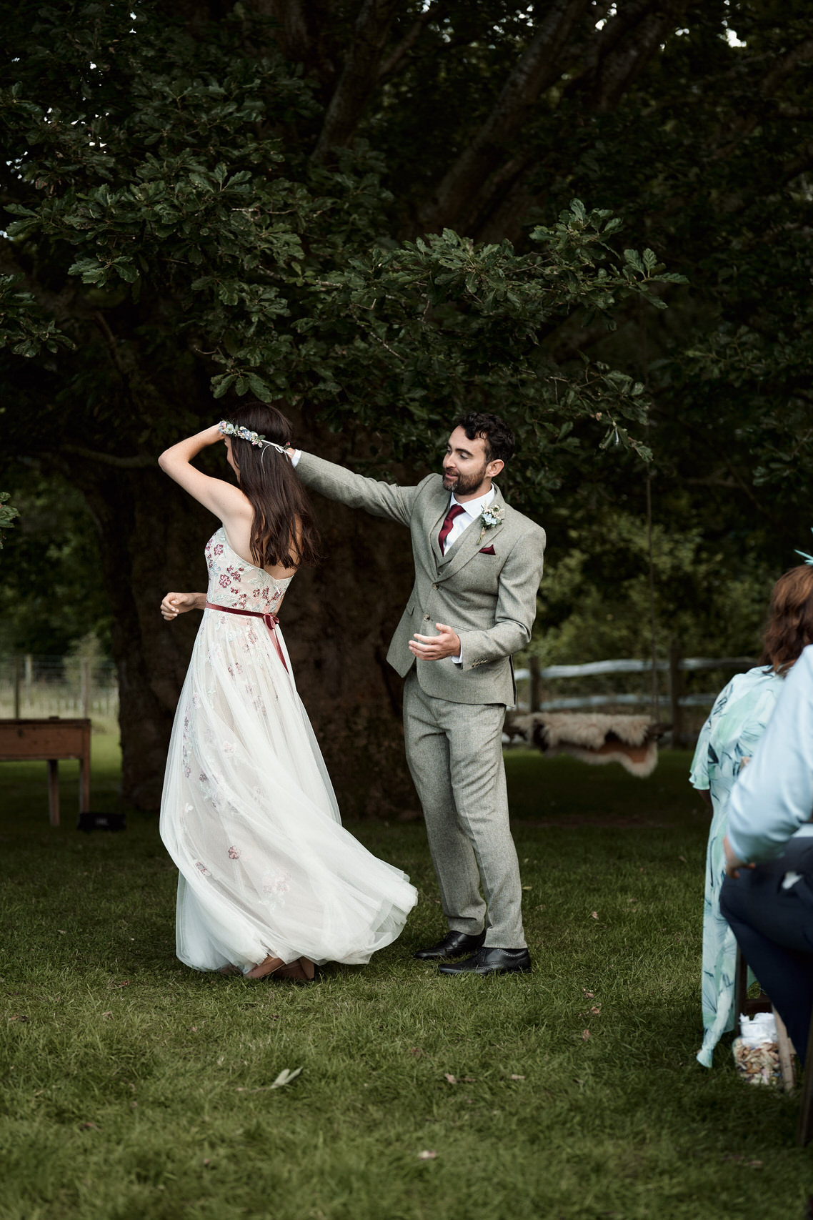 A couple getting married is dancing in front of a tree.