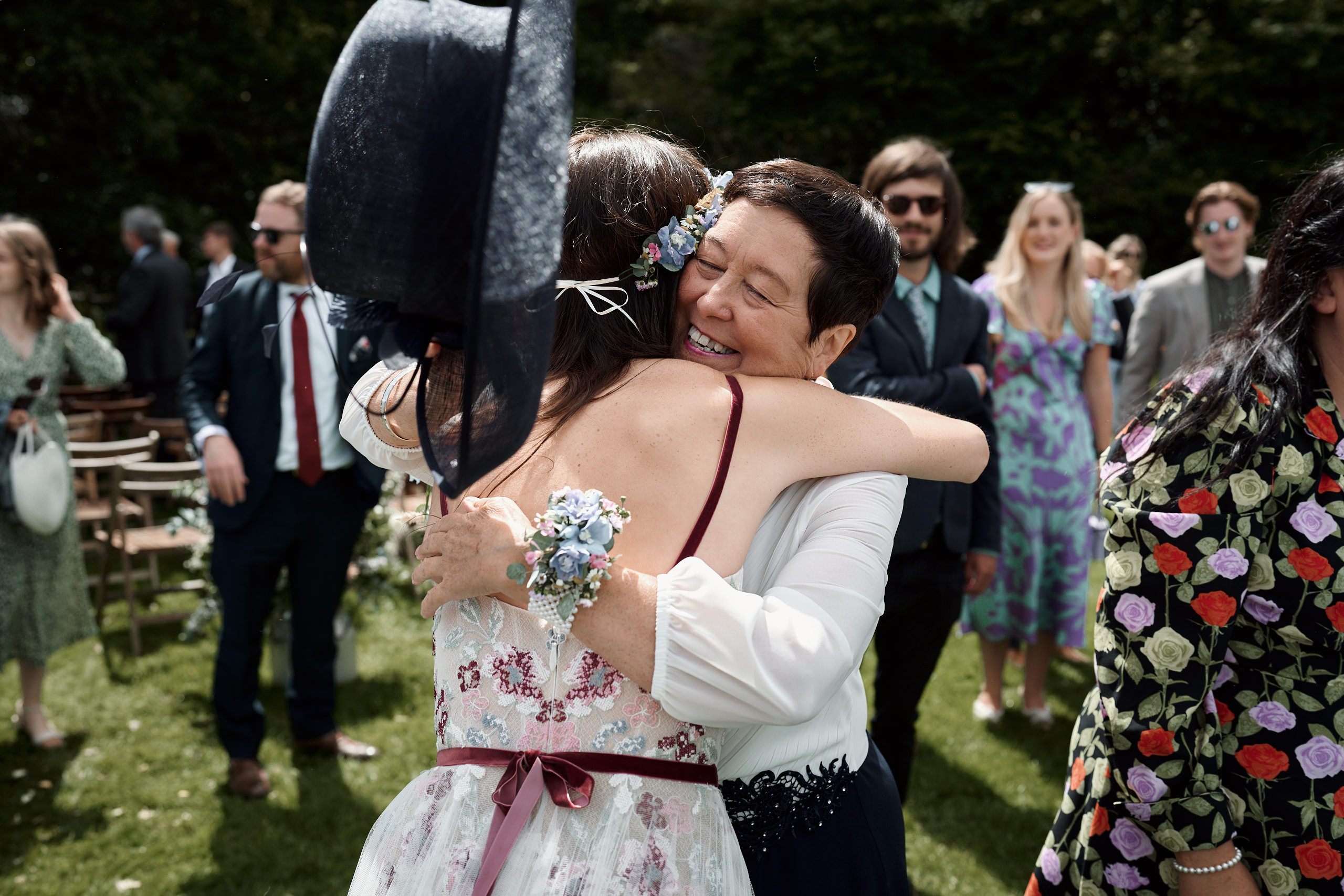 A lady is giving another lady a hug at a wedding.