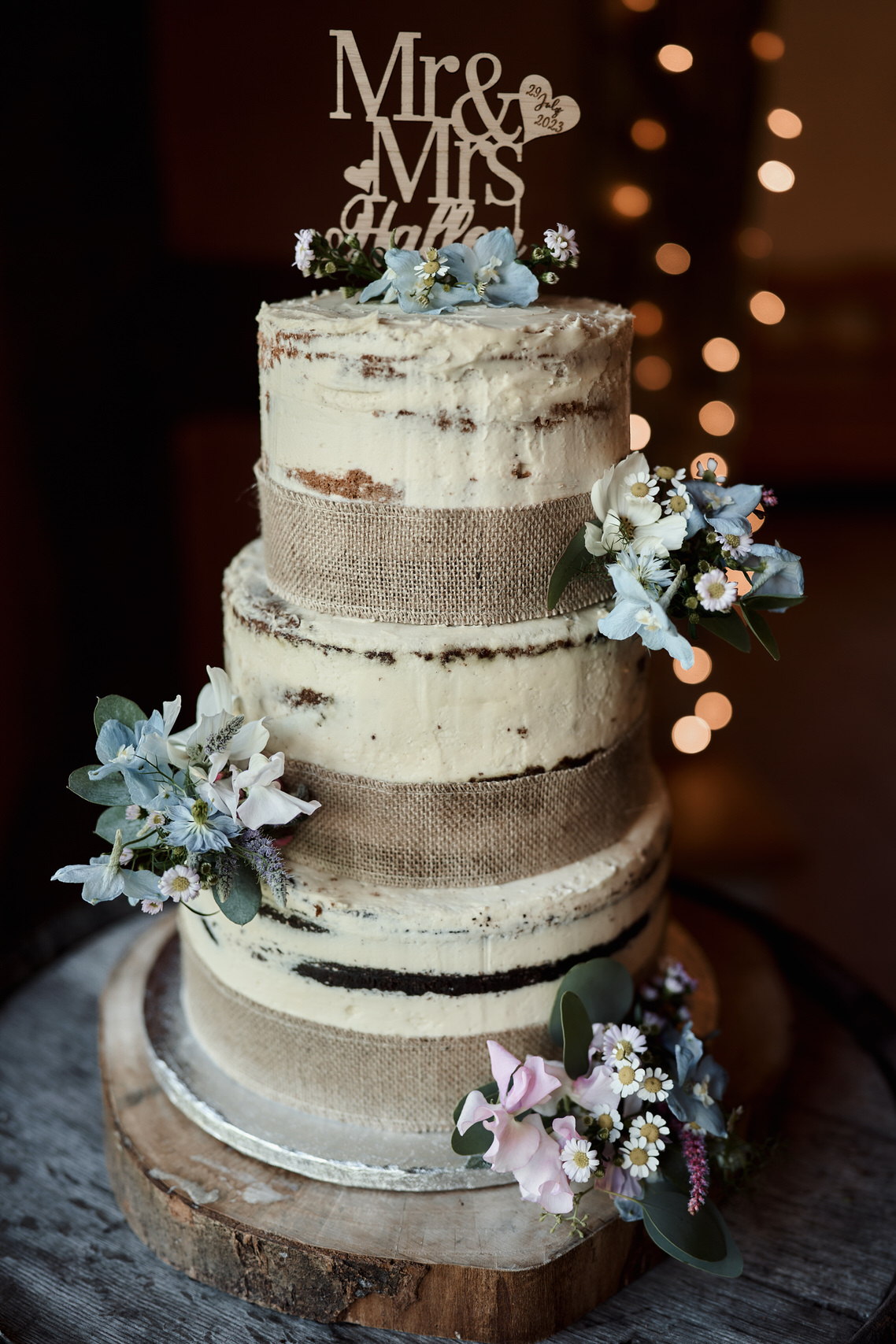 A wedding cake that has a bride and groom decoration on top.