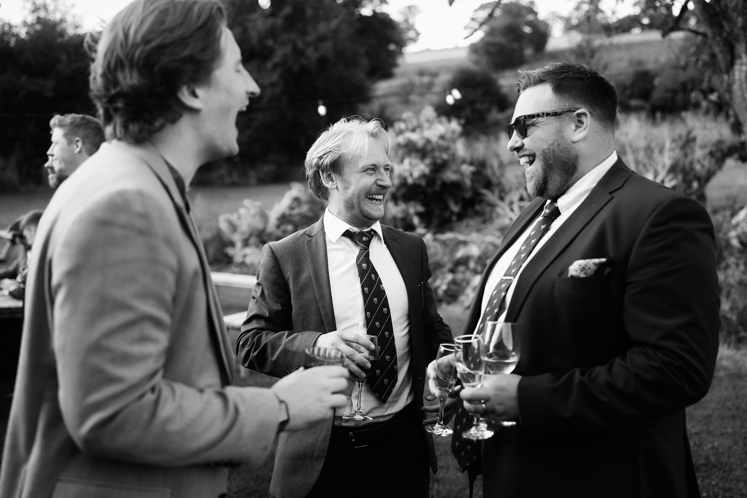A group of men chatting in a black and white picture.
