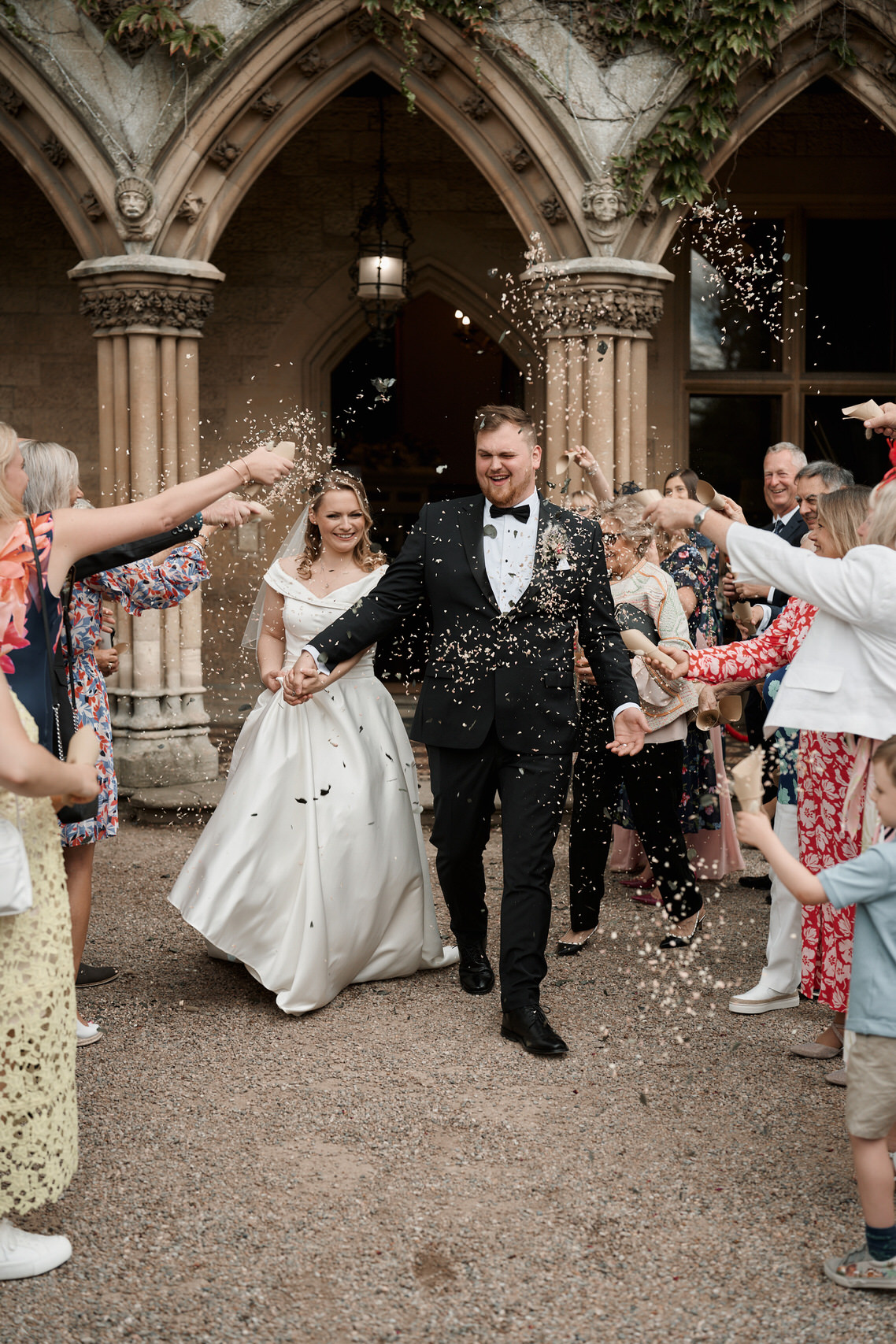 A couple getting married are tossing confetti at each other.
