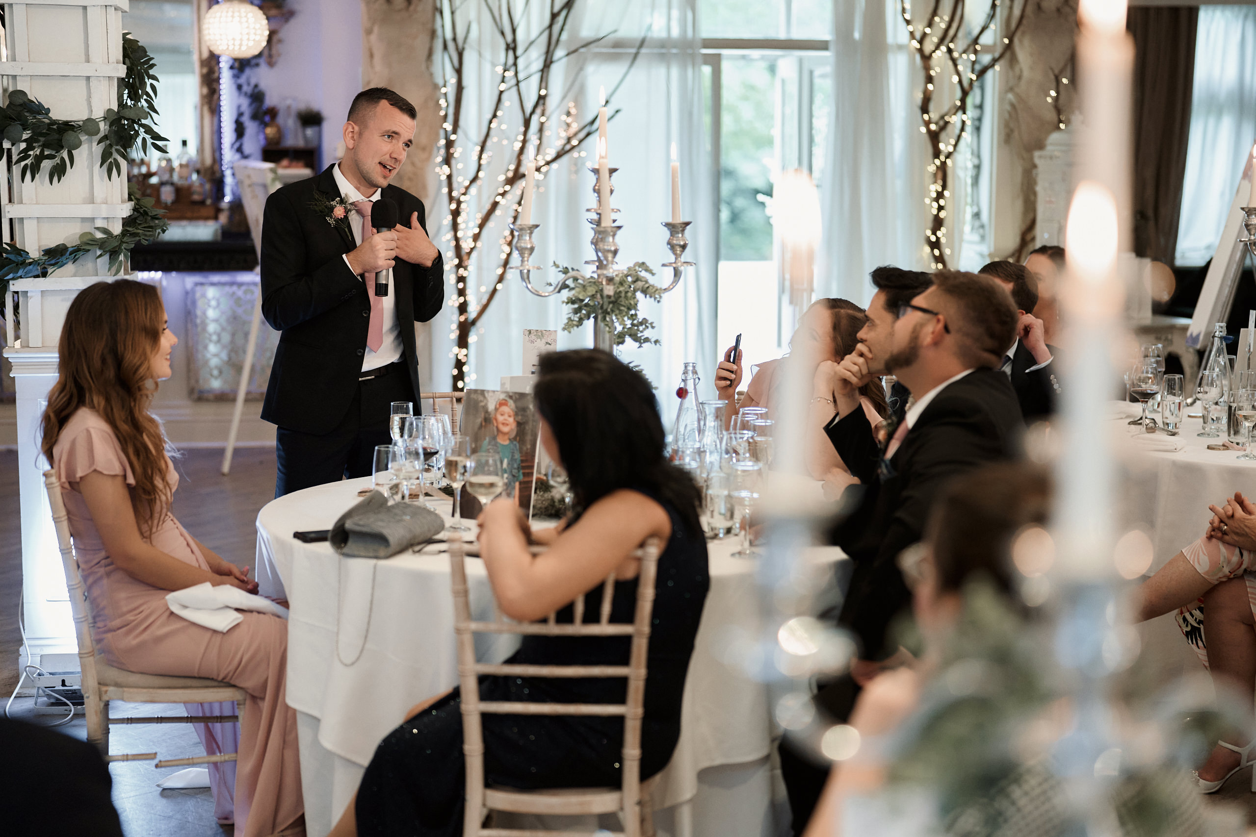 A guy speaking at a wedding party.