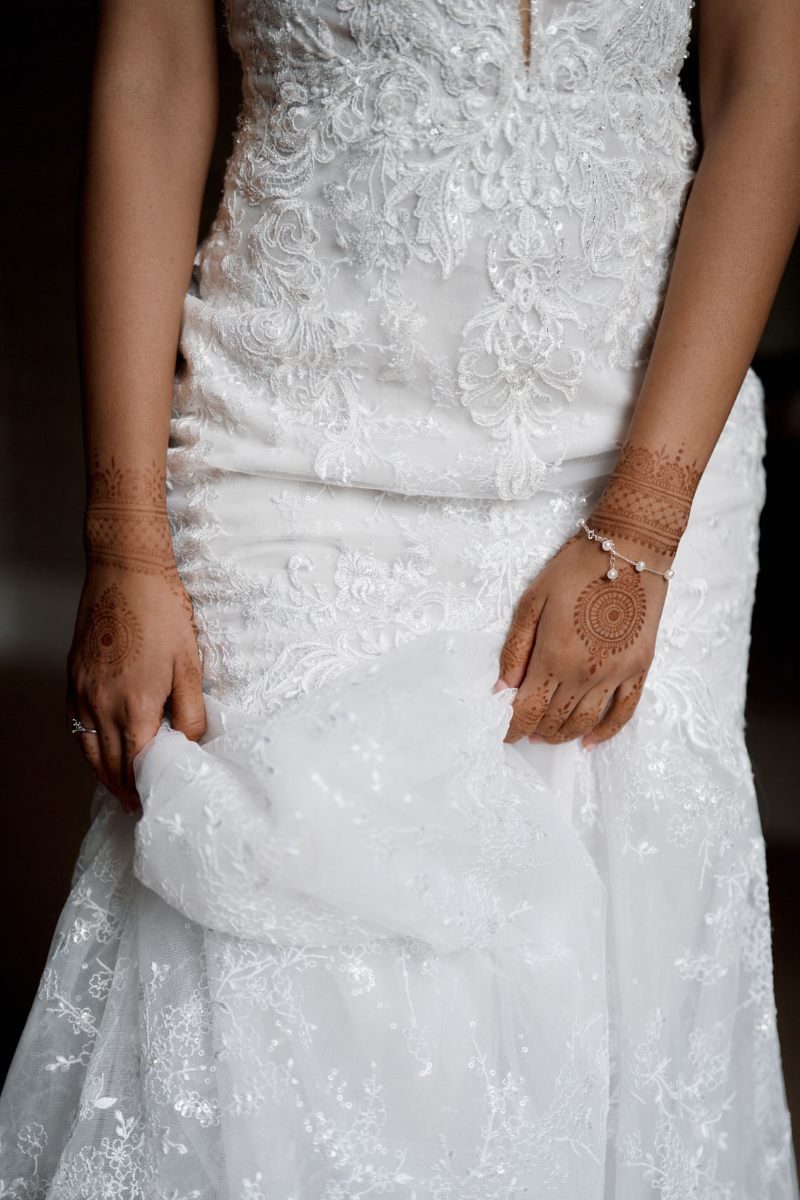 A bride wearing a white wedding dress and henna tattoos.