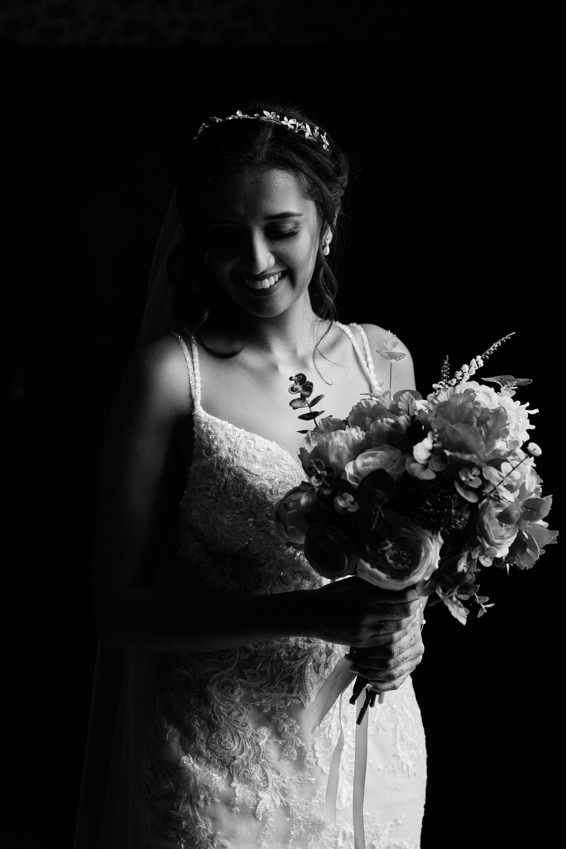 A picture in black and white of a bride holding her flowers.